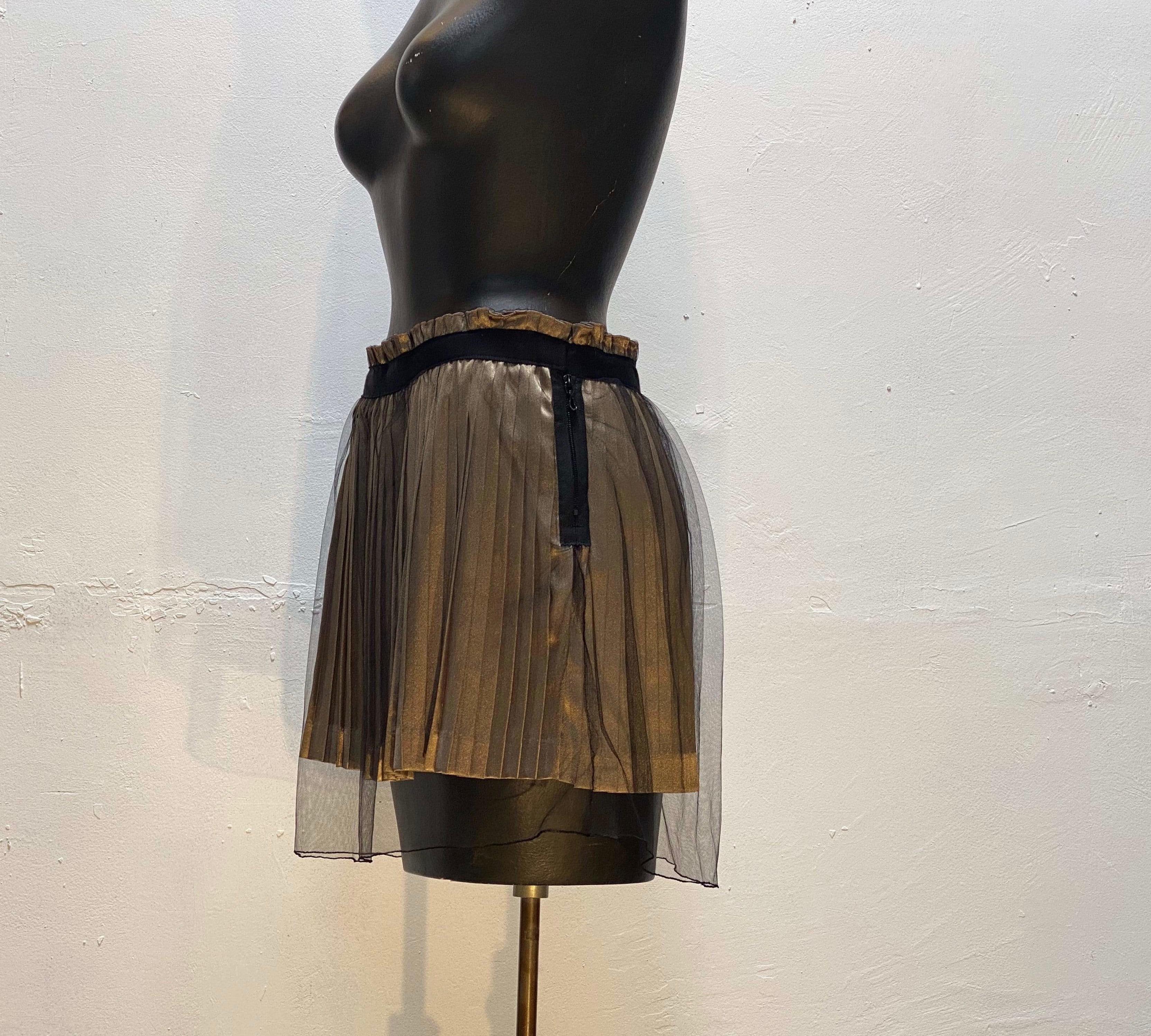 This alluring bronze, pleated satiny-soft mini skirt, from vintage Undercover, shines beneath a black mesh netting overlay. Details include a black ribbon punctuating the waistline and a side zip closure.