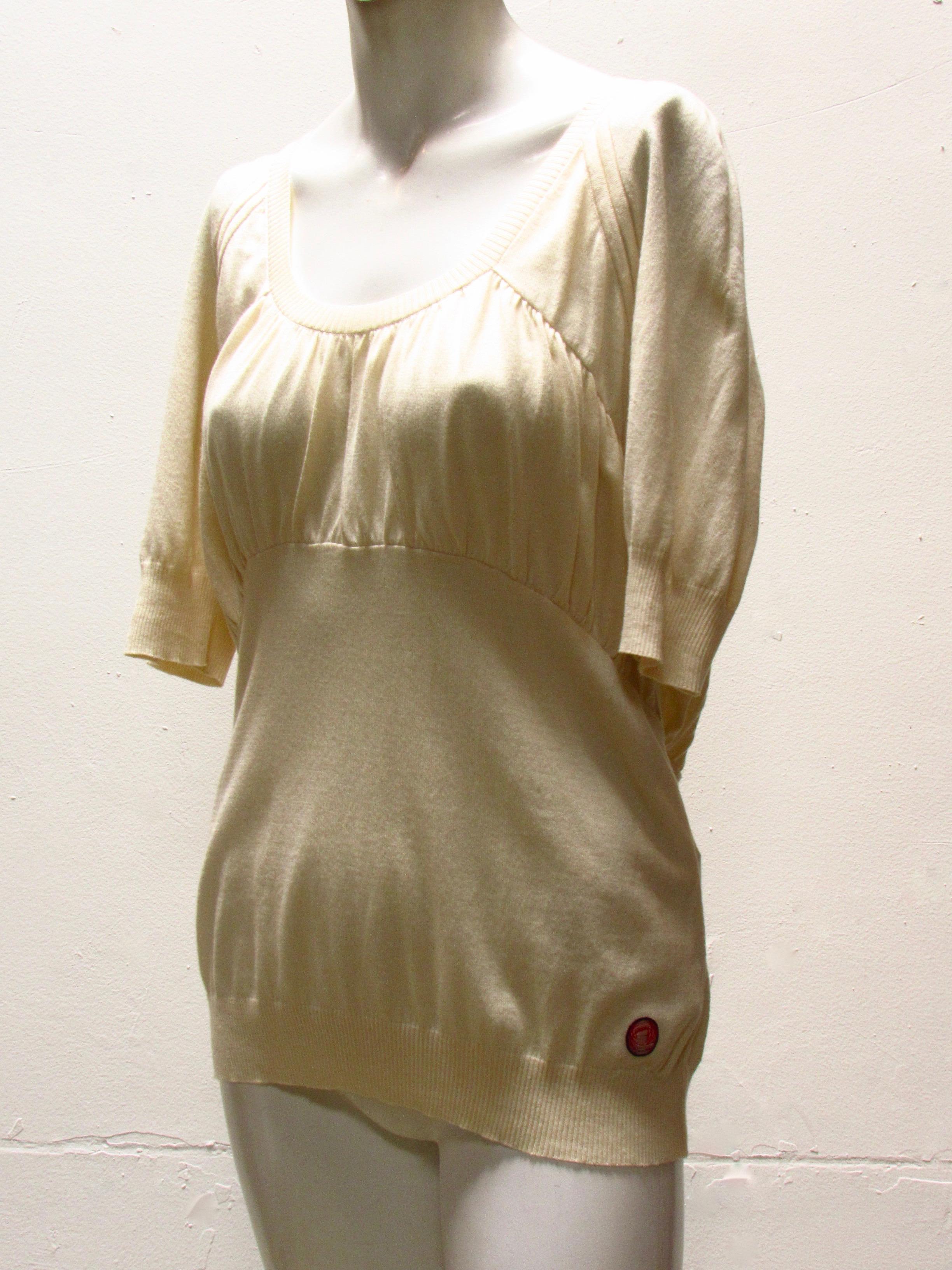 A delightfully feminine scoop neck top, from vintage Undercover. The cream-colored soft cotton/cashmere knit is gathered across the chest, continuing around to the back like a hug. Ribbed cuffs at elbows adds to the femininity of this style.