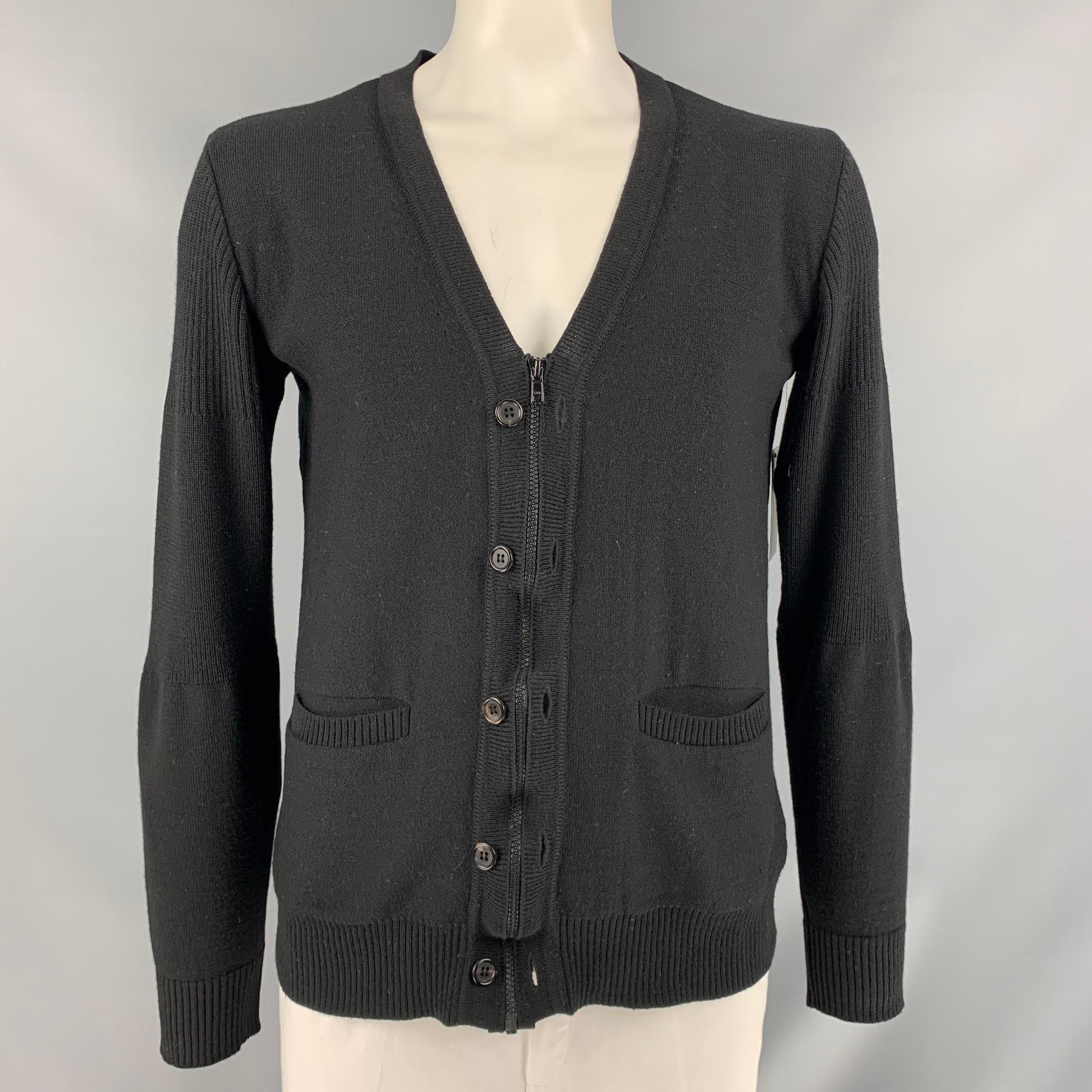 UNDERCOVER long sleeve cardigan comes in black knitted wool featuring a V-neck and zip up and buttoned closure. Made in Japan.

Good Pre-Owned Condition. Moderate Piling at Back.
Marked: 4

Measurements:

Shoulder: 18 in
Chest: 46 in
Sleeve: 28