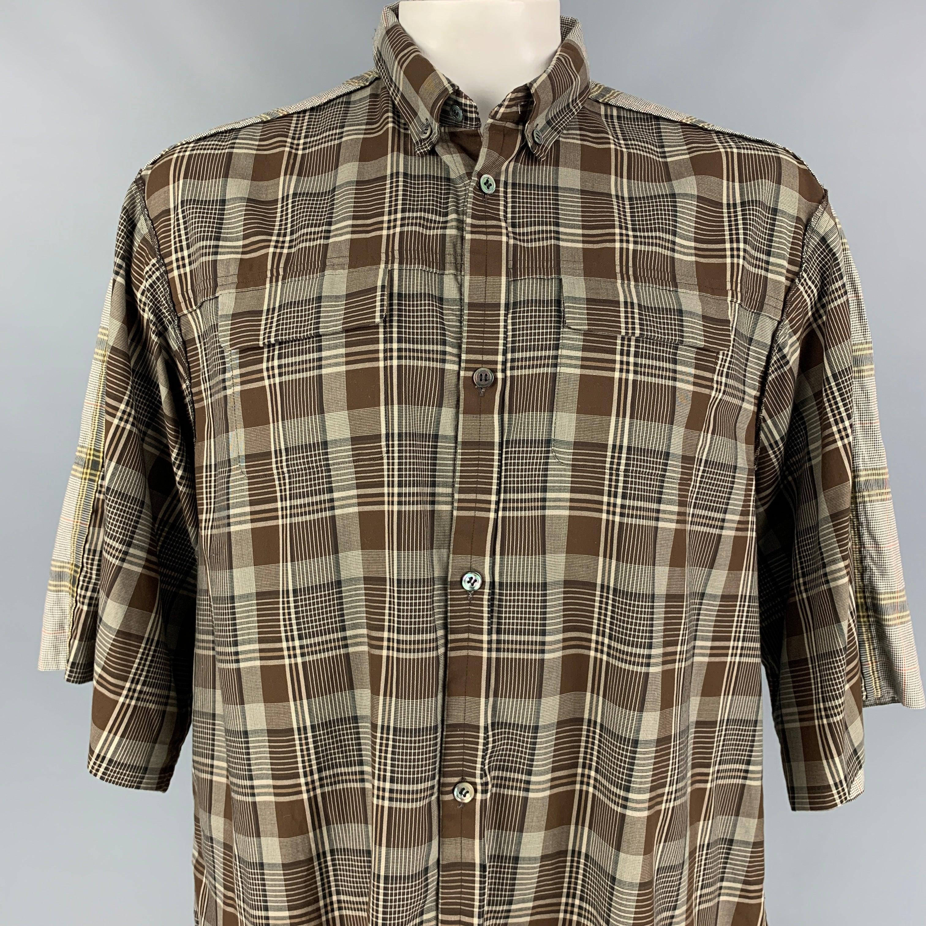 UNDERCOVER short sleeve shirt comes in a brown & olive plaid cotton featuring a oversized fit, reversed seams, front pockets, and a buttoned closure. Made in Japan.
Excellent
Pre-Owned Condition. 

Marked:   5 

Measurements: 
 
Shoulder: 21 inches 