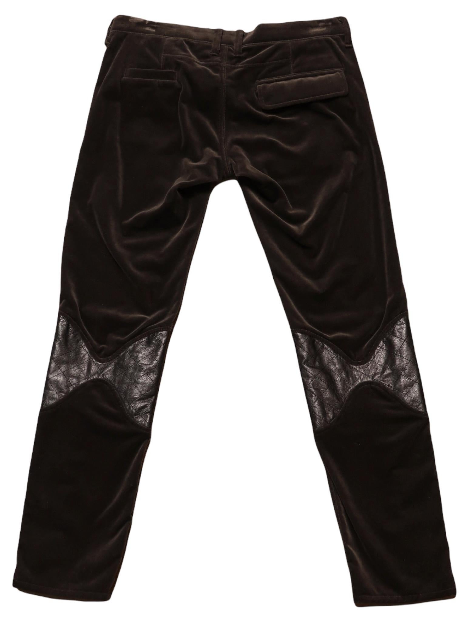 Pantalon droit vintage Undercover de couleur anthracite, doux et velouté, avec des pièces de cuir aux genoux et des jambes zippées. Fermeture à glissière et boutons-pression sur le devant, poches avant et arrière.