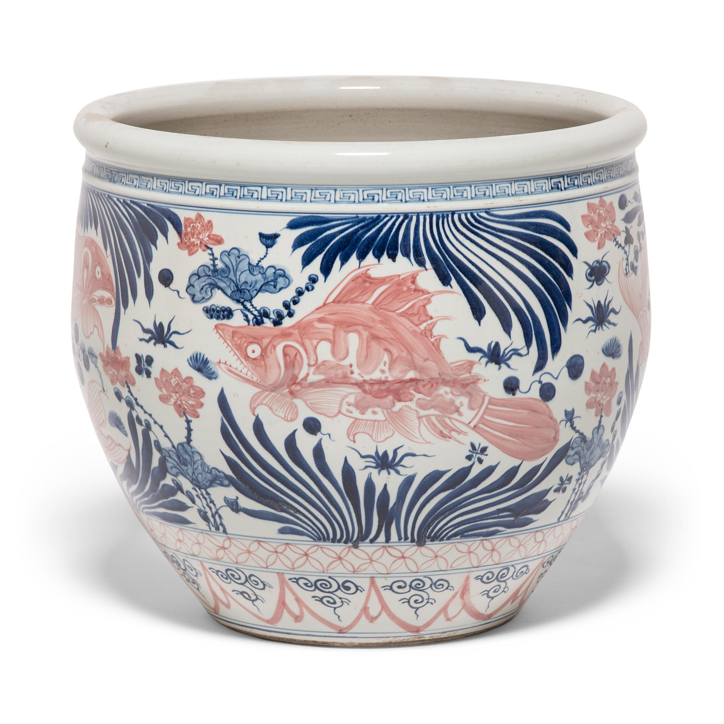 This grand, blue-and-white porcelain bowl is hand-painted with flora and fauna of the sea, offering blessings of wealth, abundance, and the contented harmony of a fish in water. The underwater imagery of this jar was hand-painted with vibrant copper