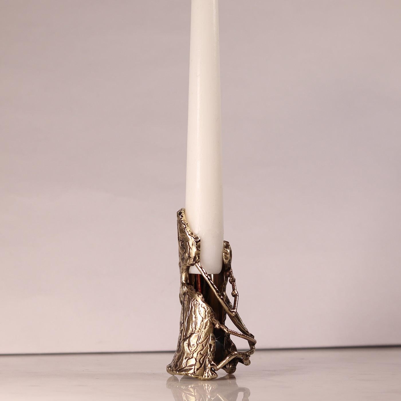 Nature changes shape and sheds its skin, leaving traces of this change on the ground. The Underwood Candlestick is made of flame-shaped brass that is beaten by hand, designed to resemble pieces of bark that have fallen off a tree. Finished with