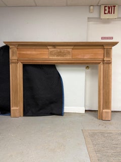 Camino in Wood non rifinito con raggi di sole intagliati e pilastri scanalati.