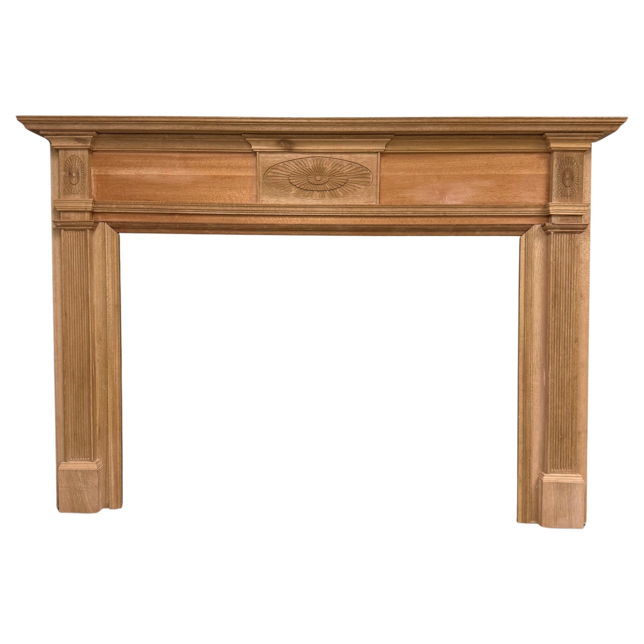 Unfinished Wood Fireplace Mantel with Carved Sunburst and Fluted Pilasters.