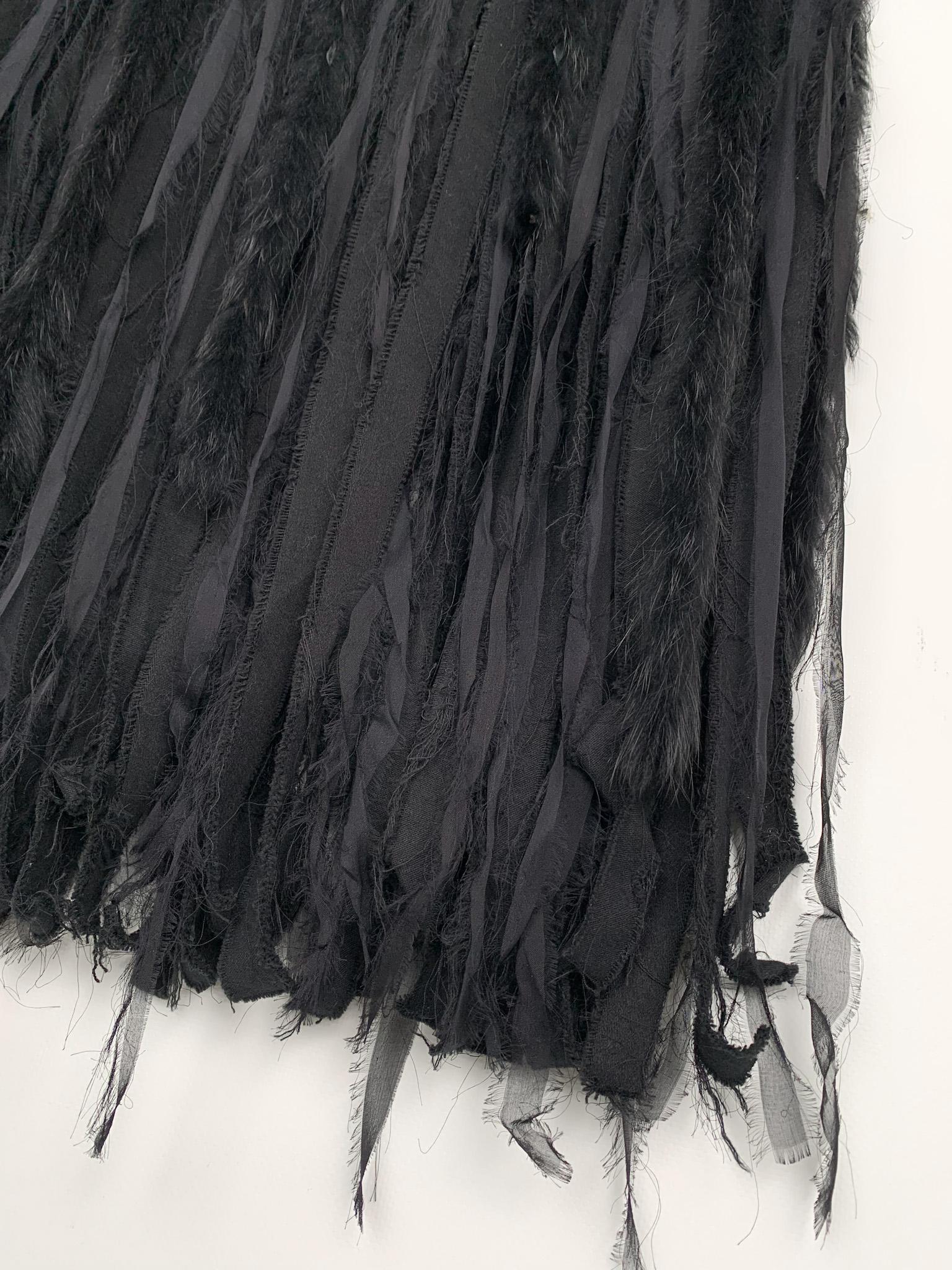 Ungaro Fever vintage 1990s (?) black denim maxi skirt, a statement-making piece that exudes a sense of flair and artistry. Made from mid-weight elastic denim, this skirt features an extravagant fringe detail that sets it apart. The fringe is made