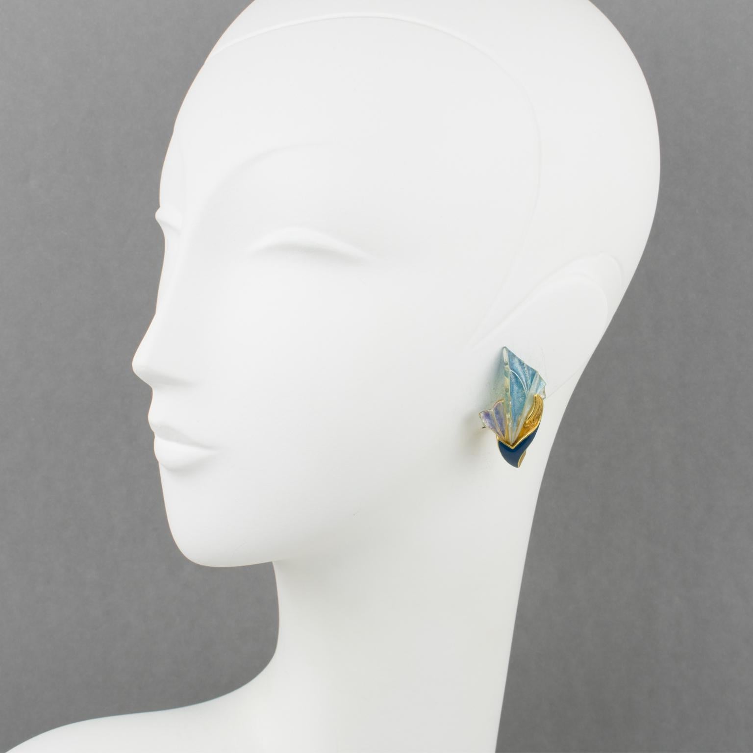 These elegant Emanuel Ungaro Paris clip-on earrings feature a gilt metal floral shape in an Art-Nouveau-inspired design. The metal framing is topped with cobalt blue enamel and complimented with an iridescent resin fan shape. The resin fan displays
