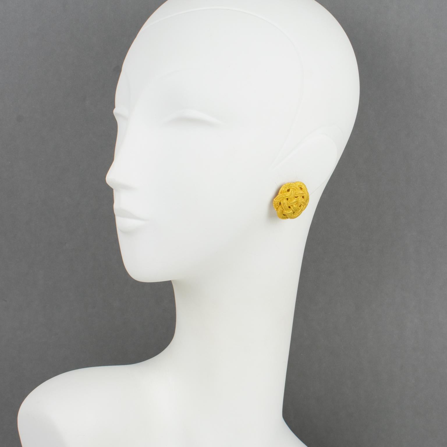 These elegant Emanuel Ungaro Paris couture clip-on earrings feature a gilt metal domed rounded shape with a braided carved pattern and satin finish texture. Each piece is signed with a tag underside reading Ungaro.
The earrings are in good