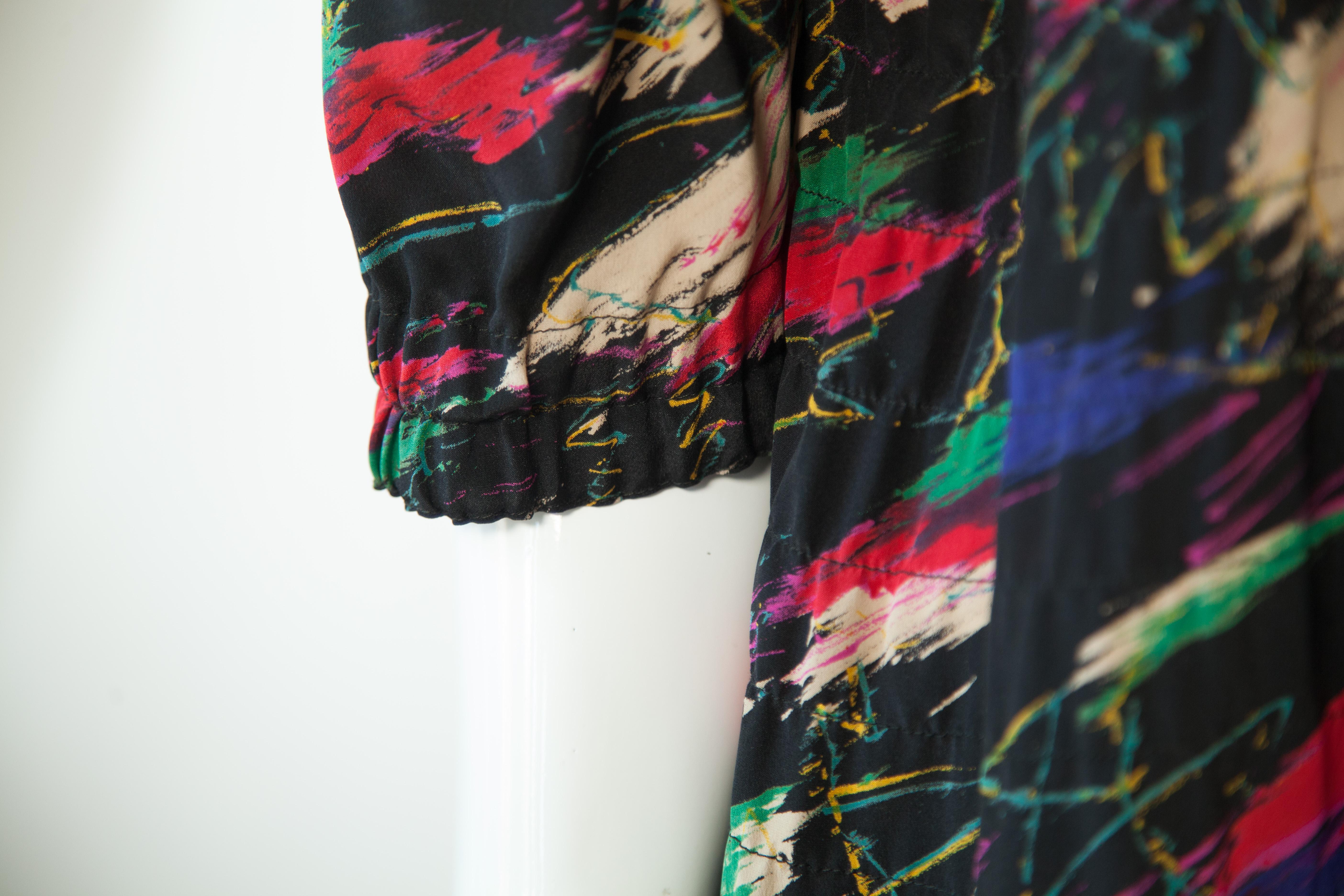 This Ungaro silk dress is the perfect addition to your wardrobe. The multi-colored silk fabric is light and luxurious, and the v-neck and 3/4 sleeves provide a flattering silhouette. This dress sits just below the knee for a sophisticated look.