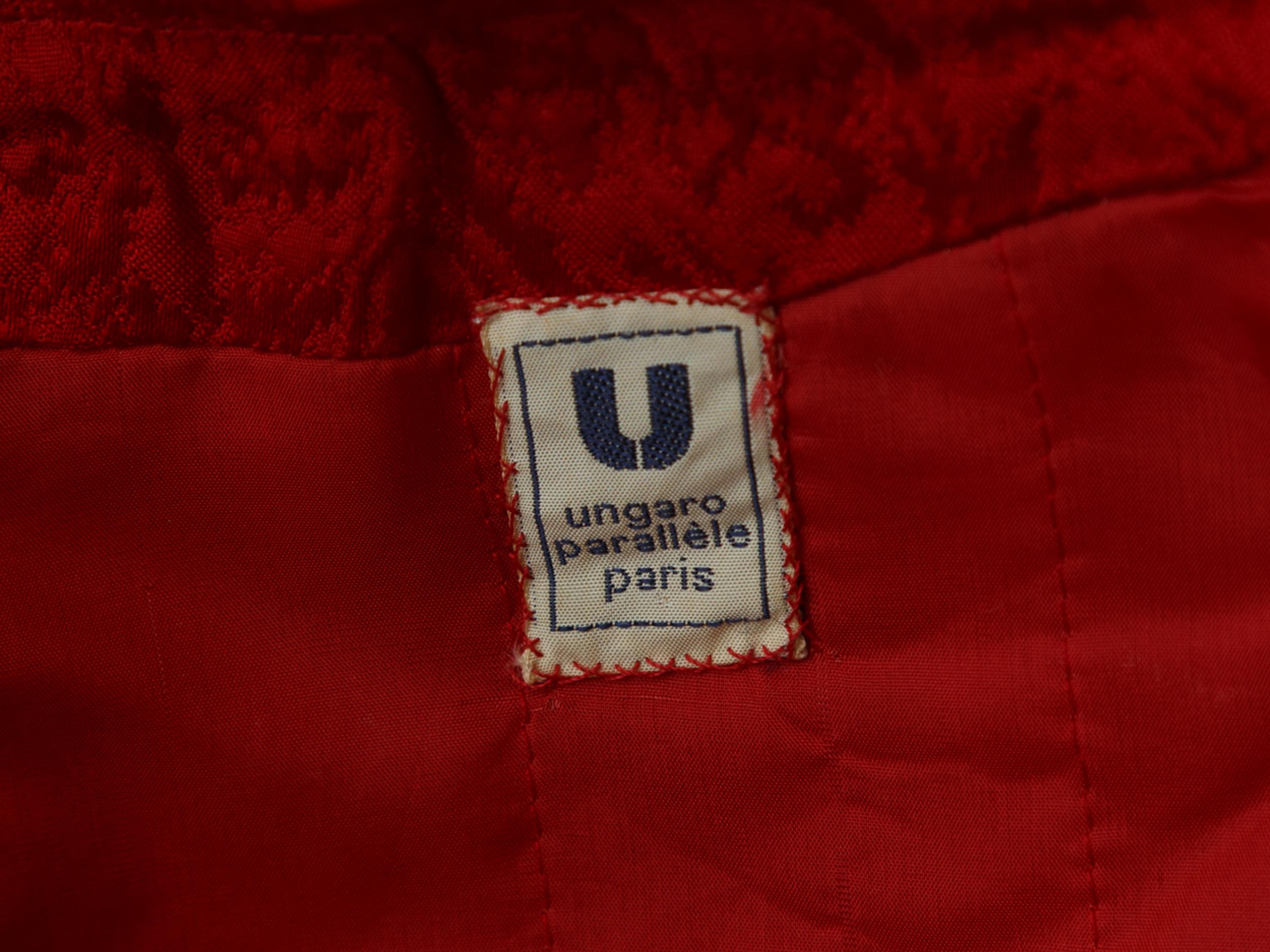 Product details: Vintage red silk brocade long coat by Ungaro. Mock neck. Tonal stitching throughout. Toggle button closures at front. 45