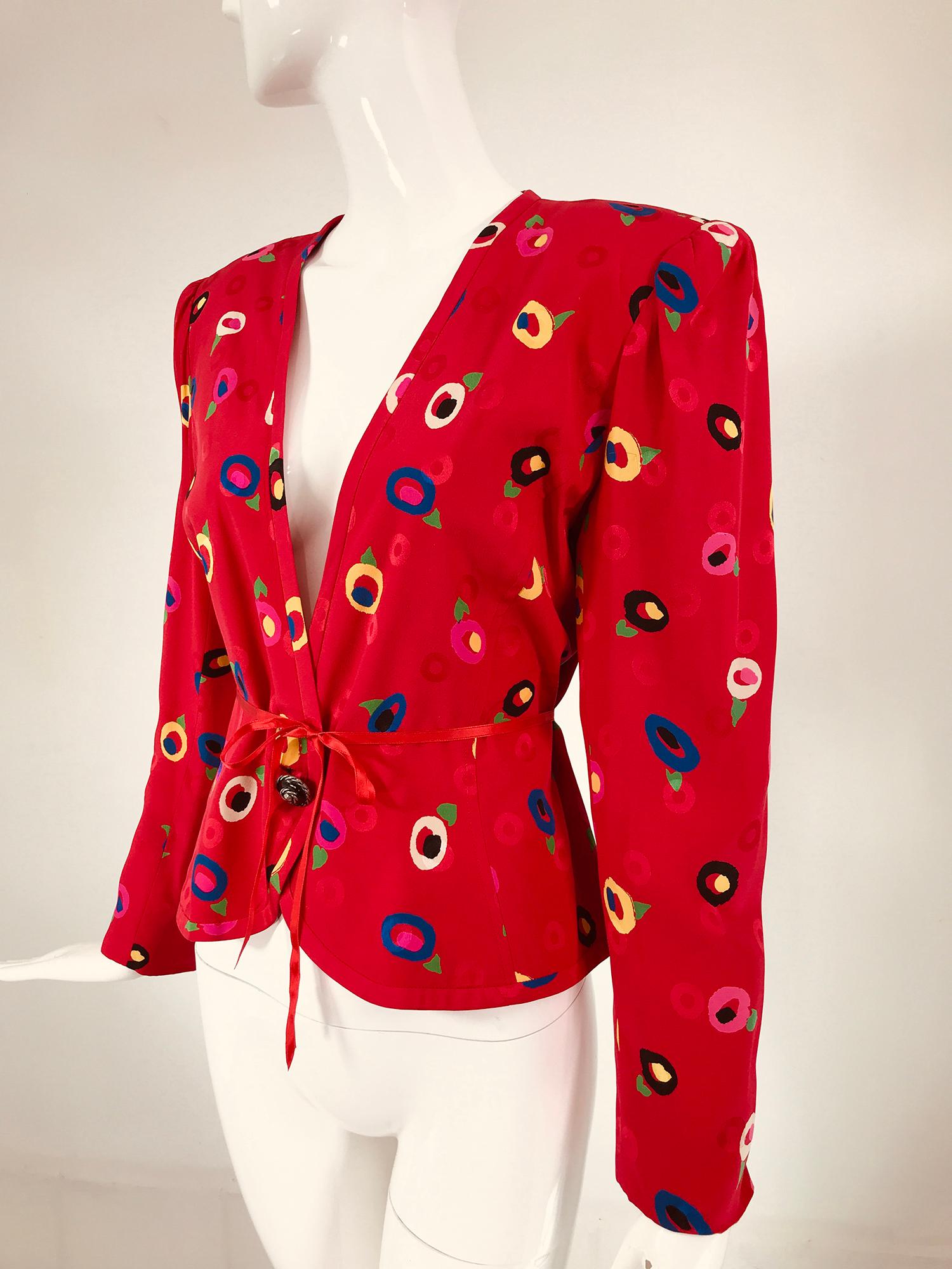 Ungaro red printed silk jacquard V neck button front jacket from the 1980s. Bright abstract flower print in yellow, black, white blue & pink on red, scattered with jacquard circles. Princess seam jacket has a deep V neckline, padded shoulders & a