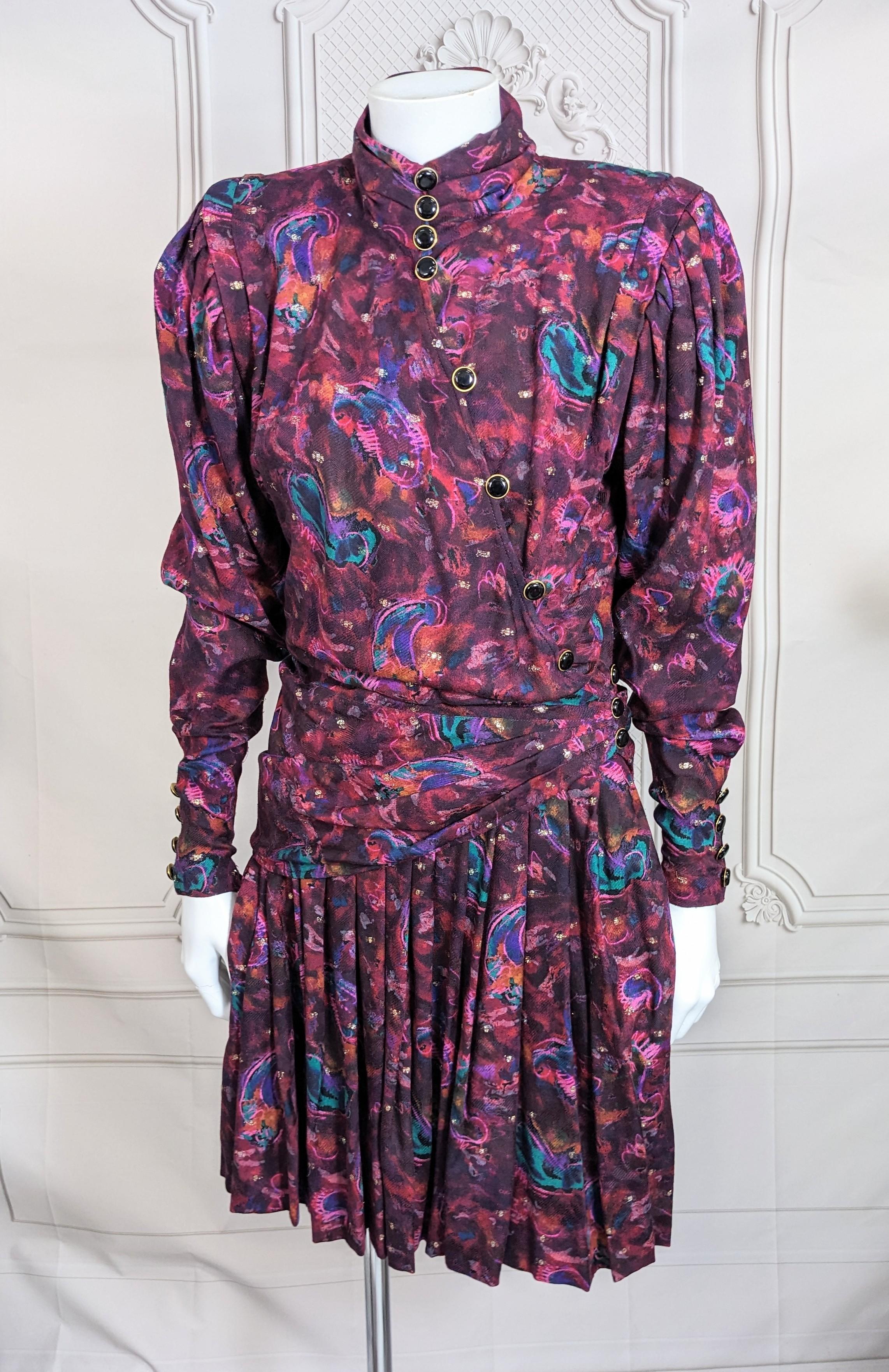 Ungaro Silk Wool Challis Lurex Metallic Ensemble from the 1980's France. 2 pieces with signature strong shoulder draped blouse with pleated mini skirt in soft abstract paisley print. 
Blouse is draped and buttoned diagonally. Inside there is a self
