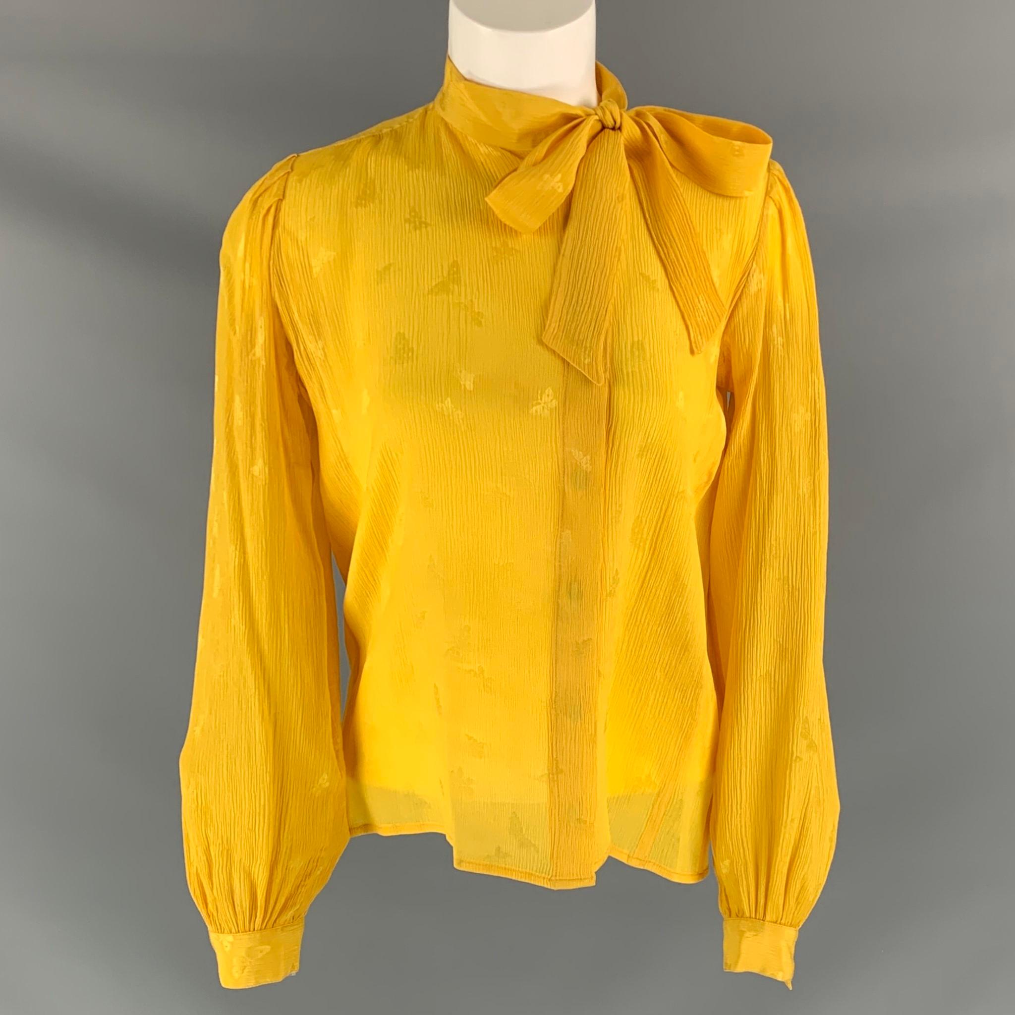 UNGARO long sleeve blouse comes in textured yellow butterfly jacquard and features a tie at neck. Made in Italy.

Very Good Pre-Owned Condition. Fabric Tag Removed.
Marked: 6

Measurements:

Shoulder: 17 in
Bust:41 in
Sleeve: 24 in
Length: 23 in