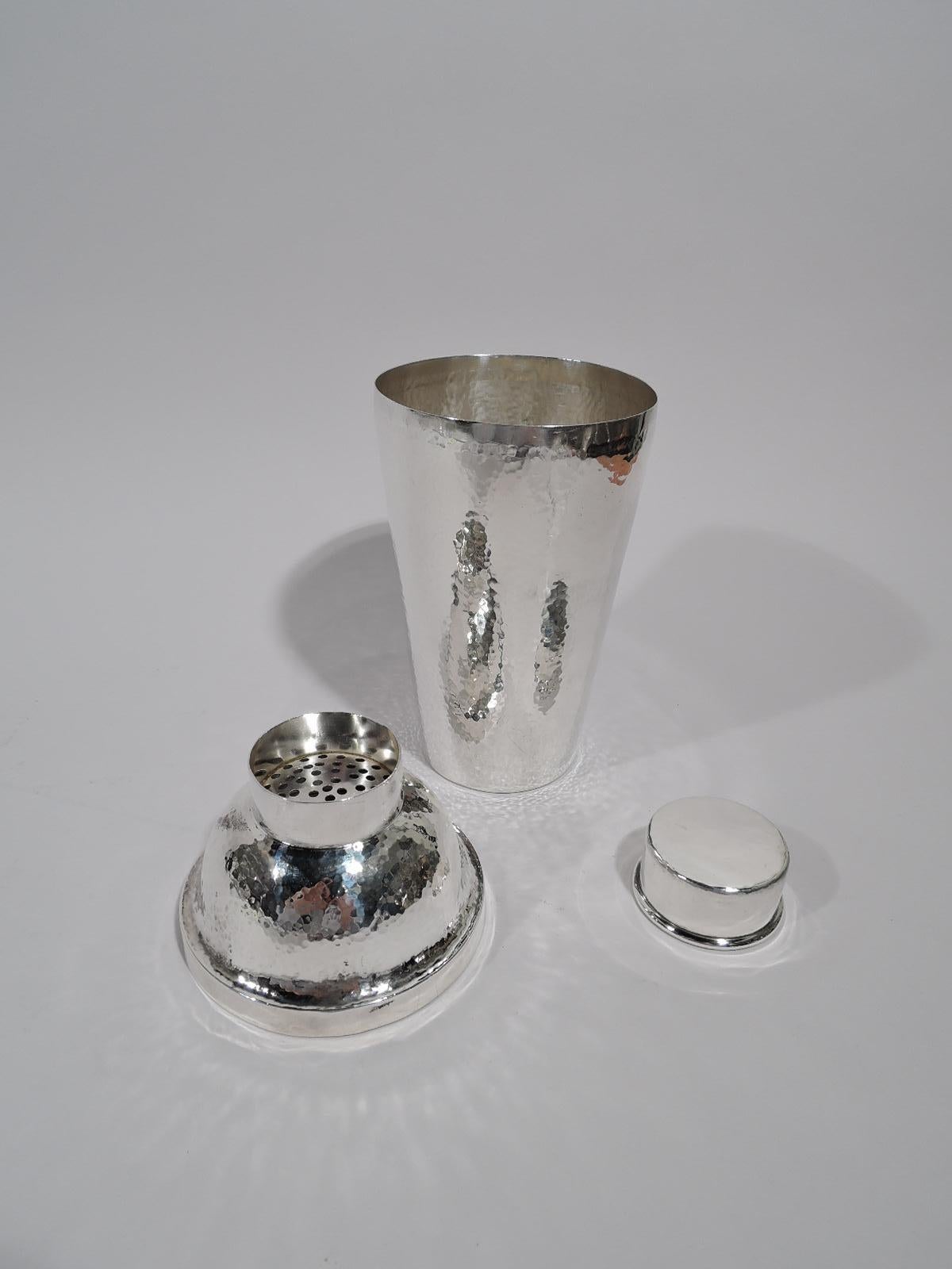 Turn of the century sterling silver cocktail shaker. Made by Unger Bros in Newark. Tapering cup; domed cover with short inset neck and built-in strainer. Cap fits snuggly. Allover hand-hammering. A fine application of Craftsman principles to a