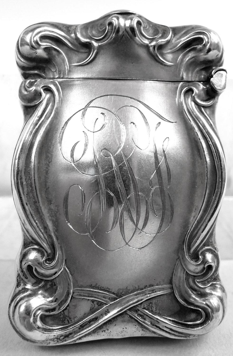 Art Nouveau sterling silver match safe. Made by Unger Bros in Newark, ca 1900. Curved with whiplash scrolls and hinged cover. On front in relief the poignant scene from Goethe’s Faust with Marguerite plucking the petals off a daisy, intoning the