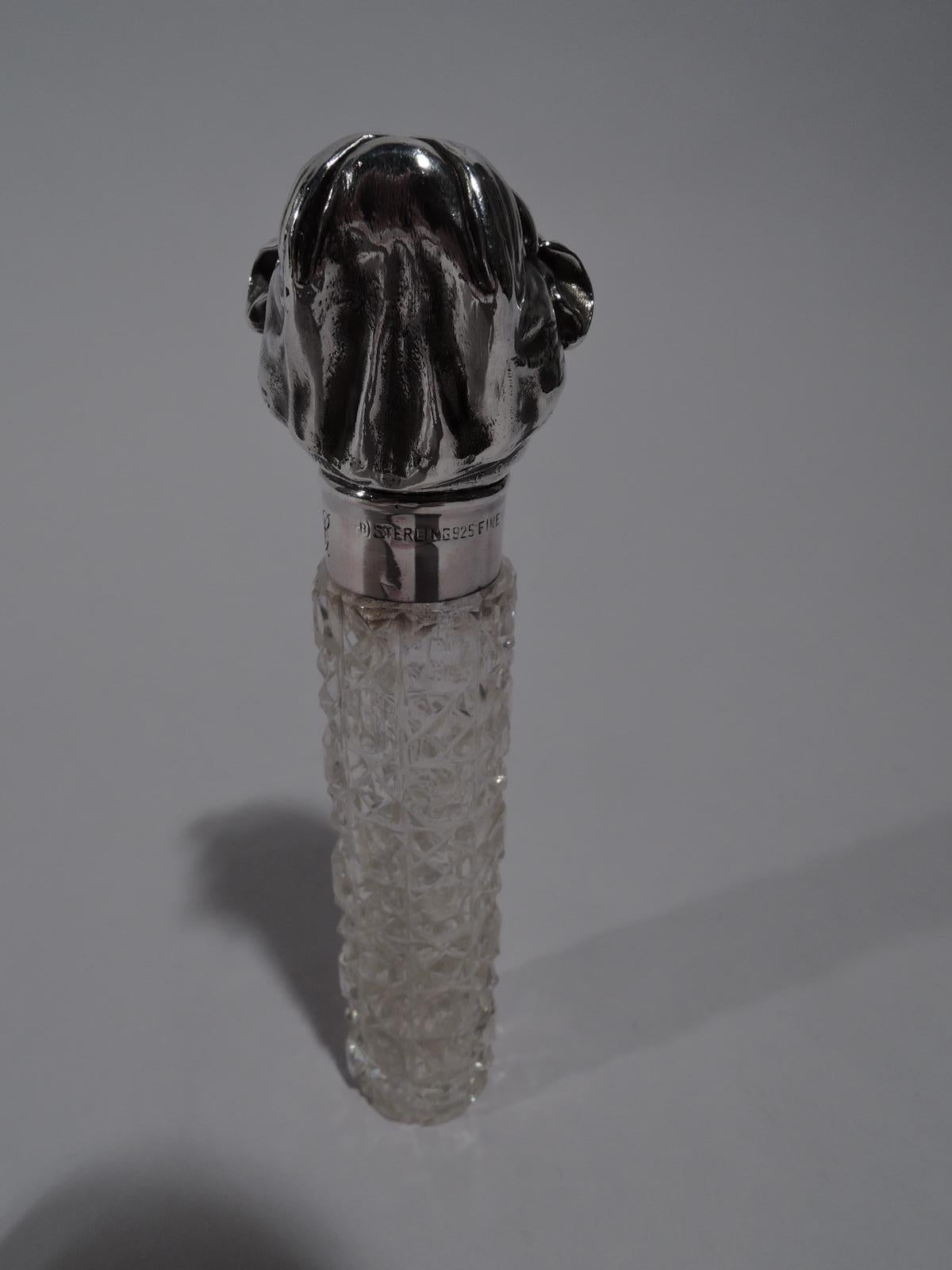 Turn-of-the-century brilliant-cut glass and sterling silver perfume. Made by Unger Brothers in New Jersey. Clear glass cylinder with diaper pattern. Sterling silver mount with hinged cover in form of growly, jowly bulldog head with red glass eyes.