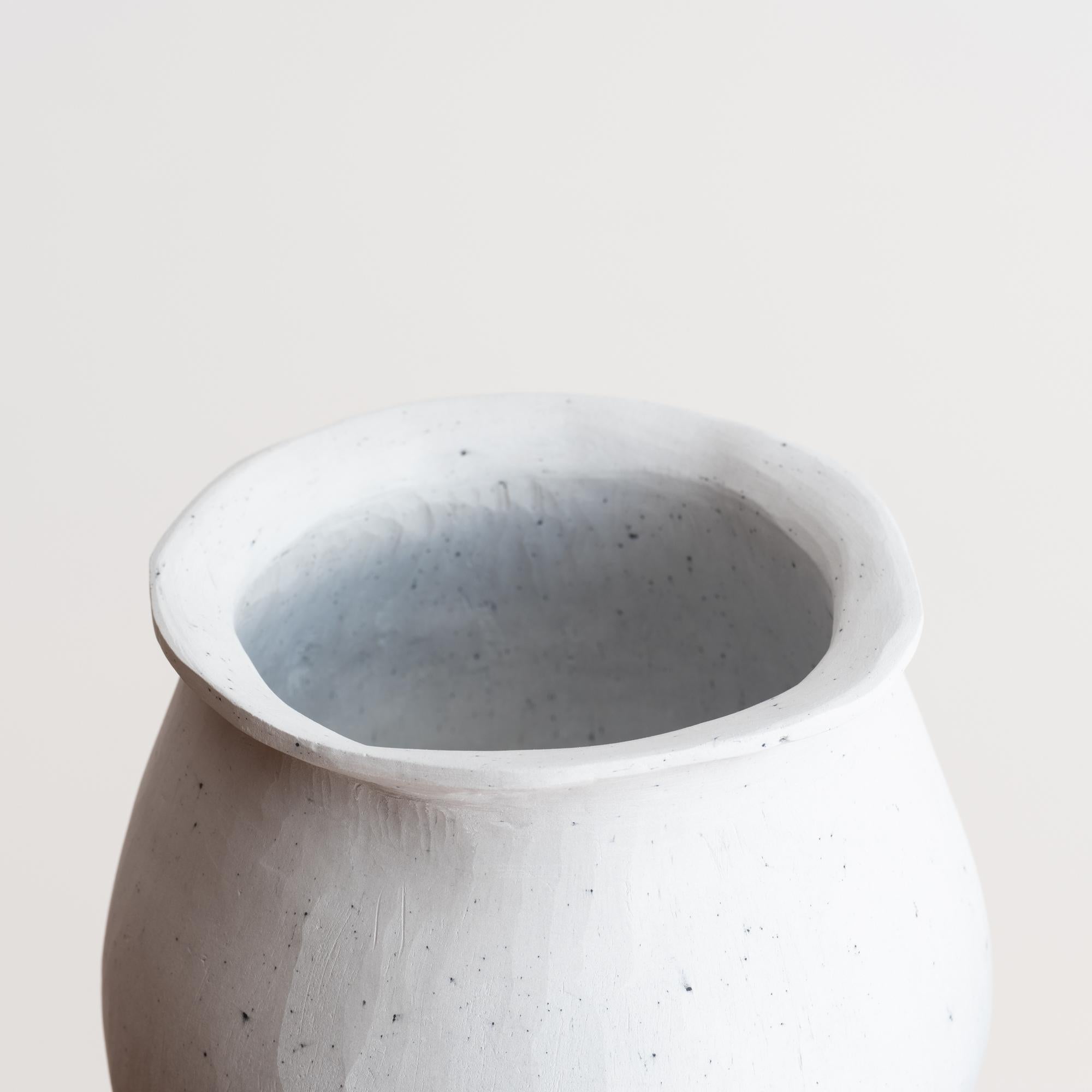 This delicate, diminutive hand-crafted porcelain vessel, entitled 'Grotto Vase,' makes a subtly beautiful addition to any room in the home. The chalky finish calls to mind the raw, tactile essence of a Giacometti plaster sculpture, while the serene