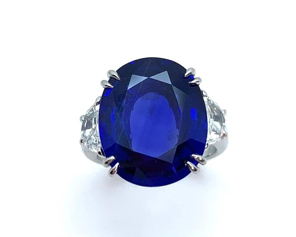 Cette bague en platine présente un saphir bleu de Ceylan rare, de couleur naturelle, serti de deux diamants demi-lune. Le saphir est accompagné de rapports du Gemological Institute of America Origin et de l'American Gemological Laboratory Prestige,