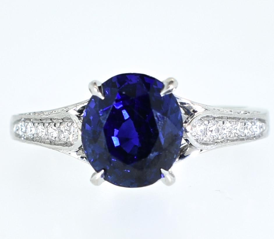 Sapphire and diamond ring.  The center sapphire which is exceptionally clean, with a bright royal blue color and certified to be natural and unheated and weigh 3.02 cts.  The .75 cts. of round brilliant cut diamonds are all fine white stones - G/H