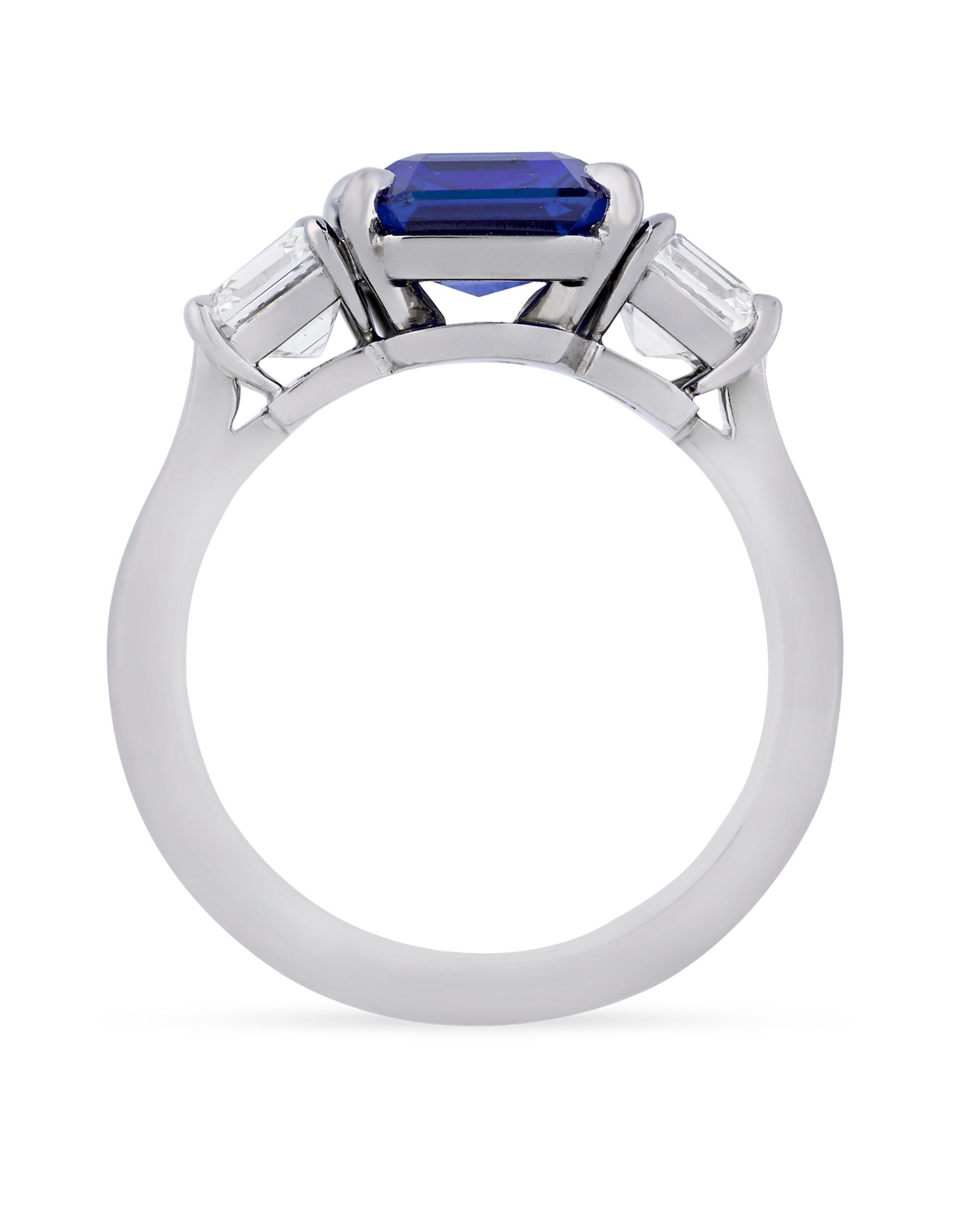 This remarkable octagonal step-cut Kashmir sapphire achieves the deep, velvety blue hue so prized in these gems. Weighing 3.32 carats, the stone's vibrant color is completely natural and perfectly complemented by two emerald-cut white diamonds