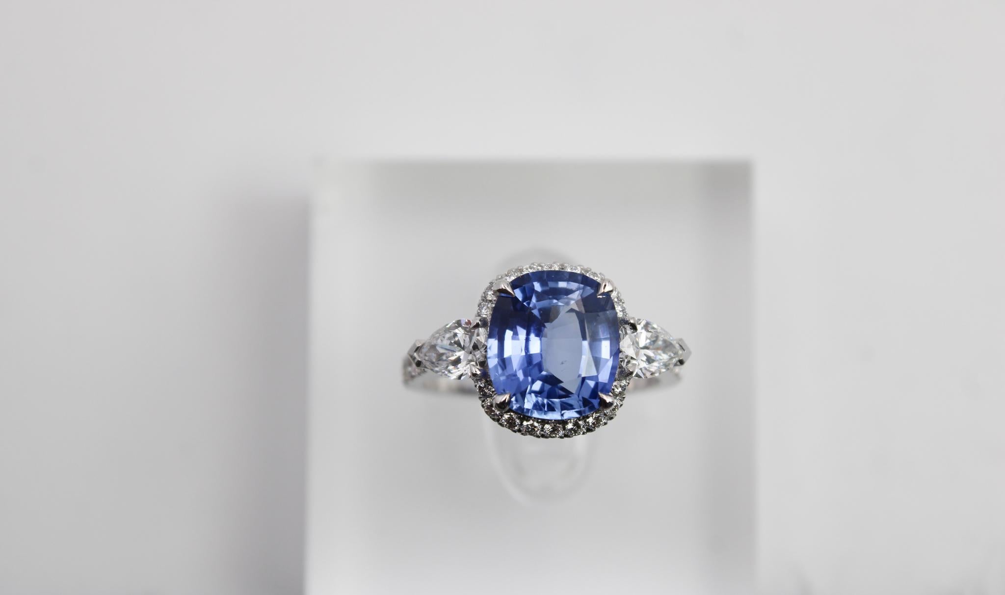 This exceptional ring features a stunning 4.13 carat natural sapphire of Sri Lankan origin, certified by GRS with no indication of thermal treatment. The sapphire is cushion-cut, displaying an elegant balance of depth and brilliance, and is securely