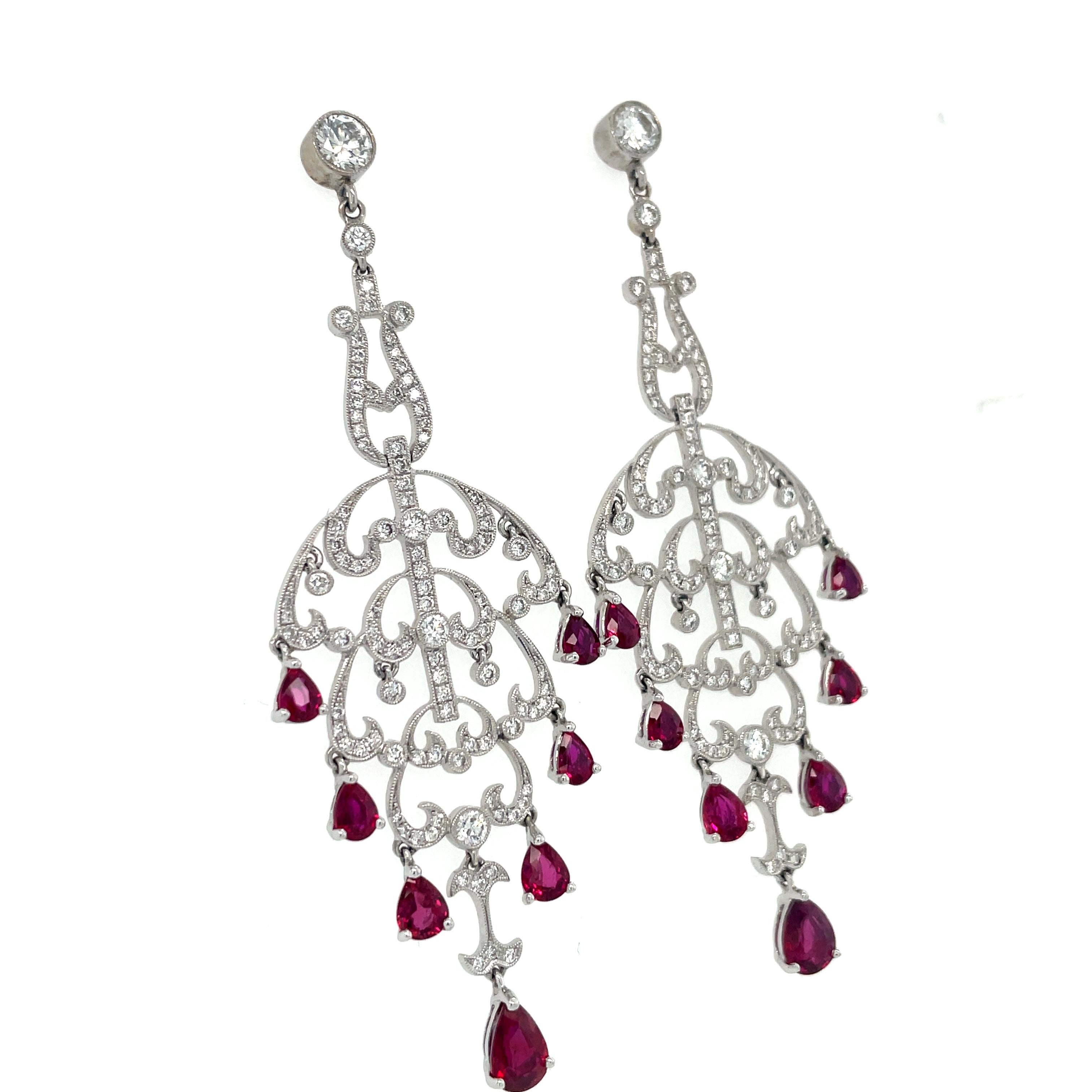 These gorgeous earrings in a swirling openwork design containing 115 top quality round brilliant cut diamonds weighing approximately 2.00 carats total, suspending 14 pear shape ruby drops. The extremely fine rubies and bright diamonds are eye