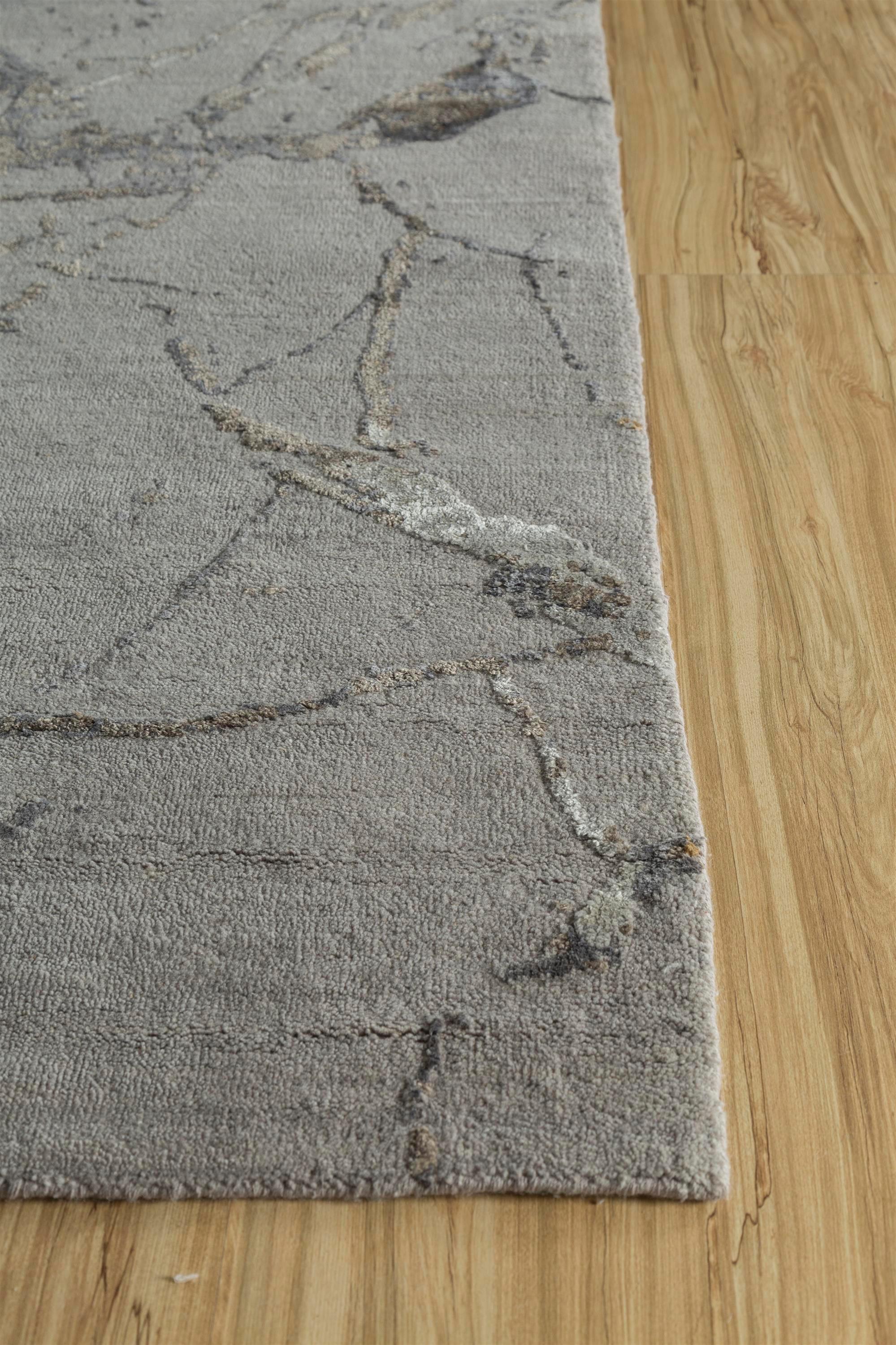Embárcate en un viaje hacia el sereno encanto de esta alfombra anudada a mano que refleja los procesos naturales de la vida. Con un fondo de madera de fresno y un borde marrón grisáceo, este moderno diseño capta la esencia de la belleza constante y