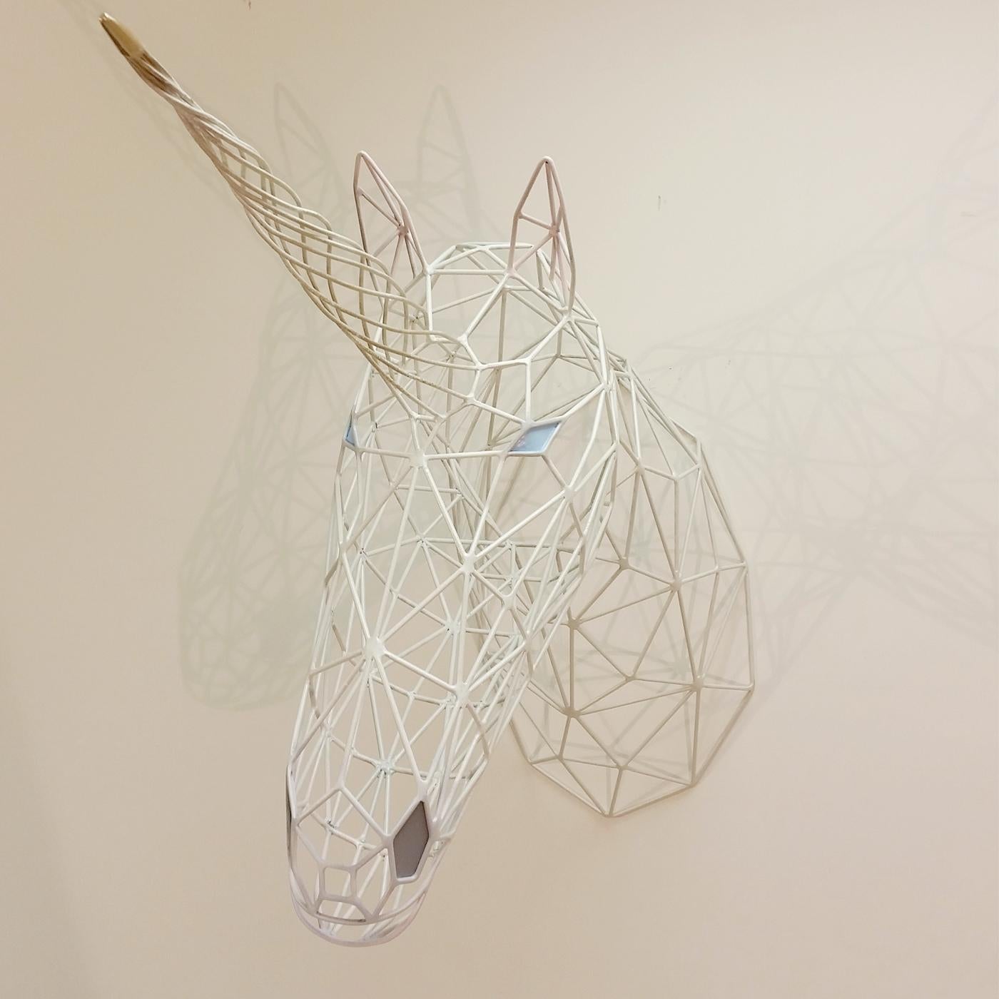 A playful and modern interpretation of the traditional trophy, this sculpture is a stunning work of art, entirely made by hand without the assistance of electronic tools. This elegant piece creates the three-dimensional Silhouette of a unicorn head