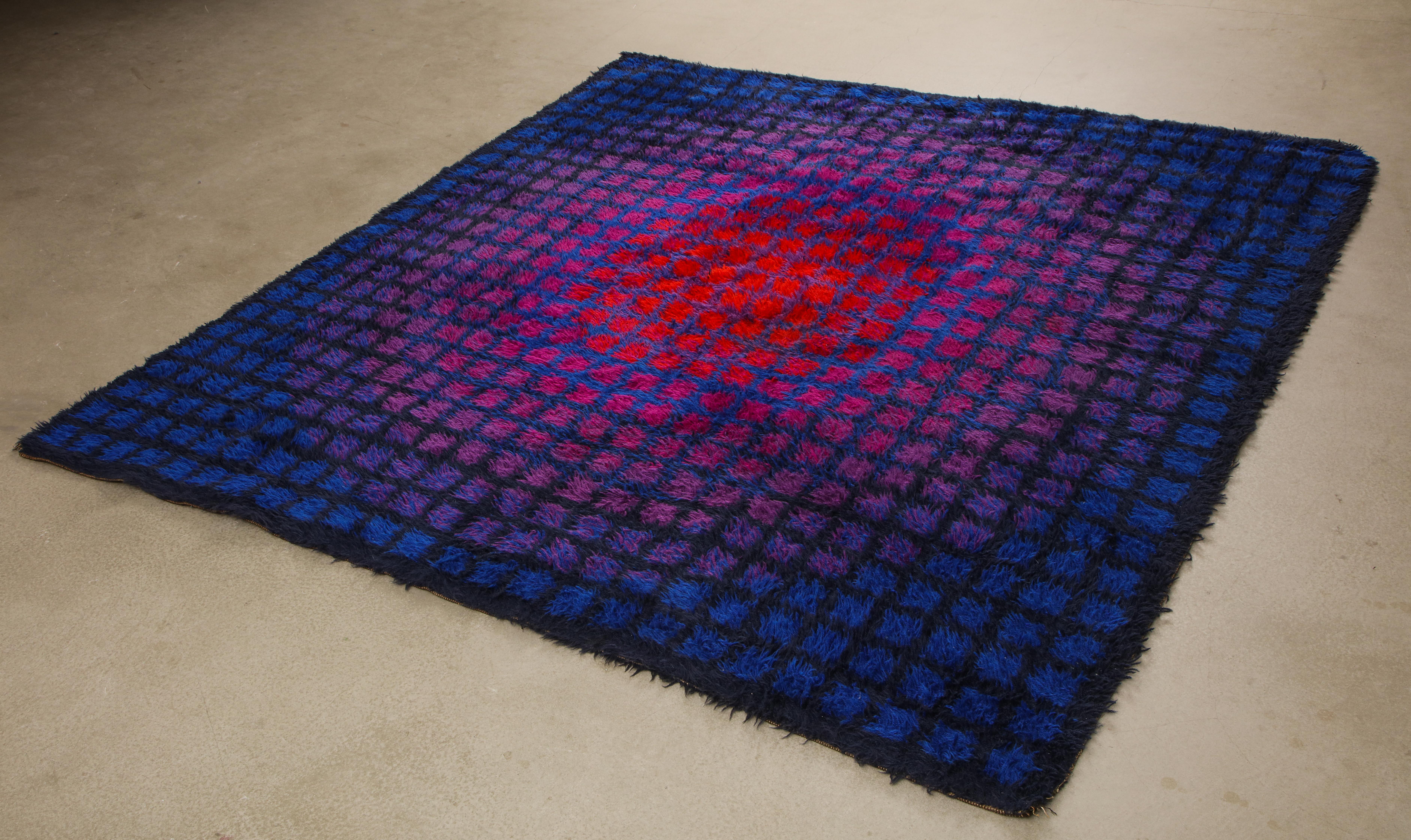 Large, square-format, long pile rya rug of Scottish and New Zealand wool. Made by the renowned Danish textile company Unika Vaev, circa 1968. In the style of Verner Panton or Vasarely, who are often credited with the design. The red-purple-blue