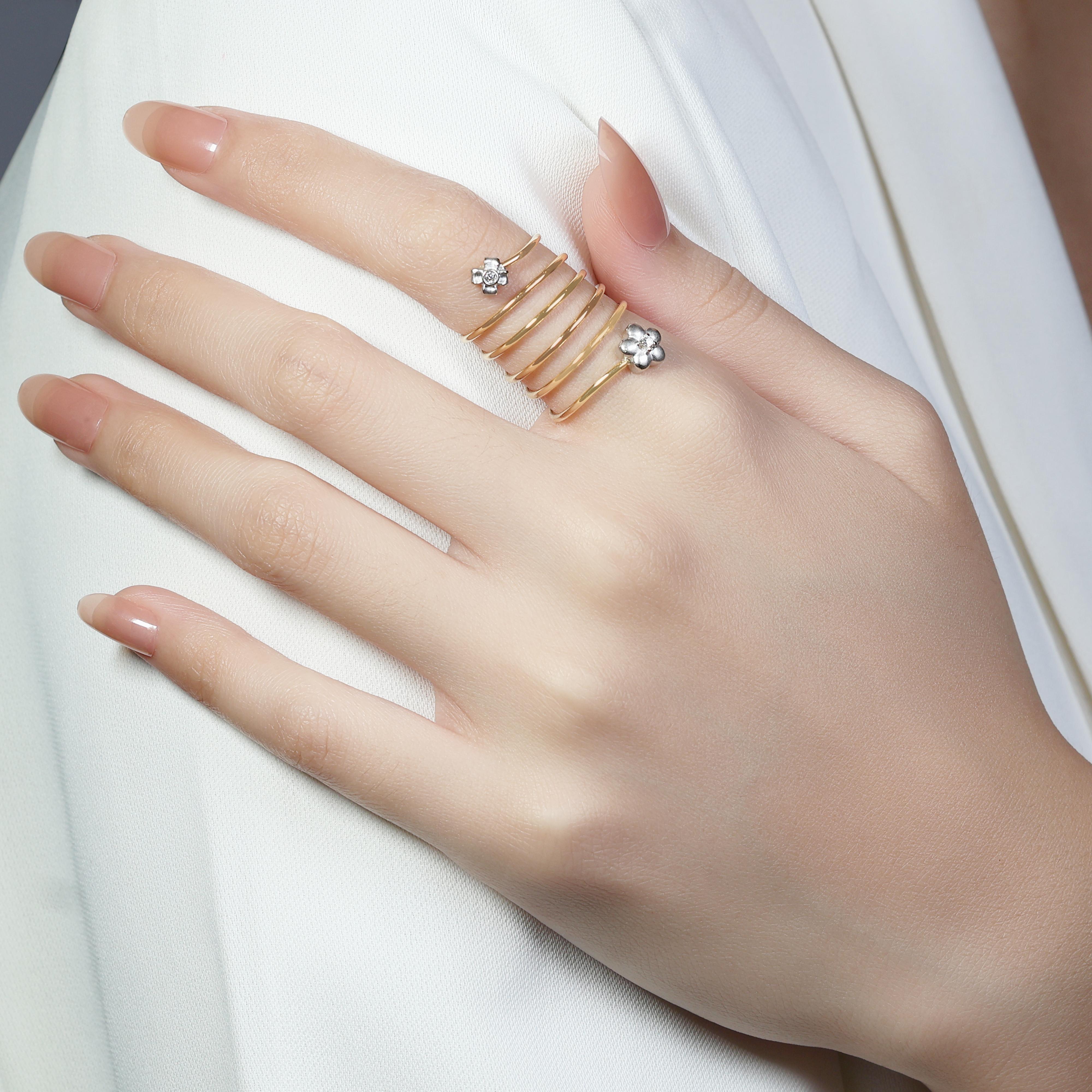 This unique 18K Yellow Gold Spiral Ring features two delicate round brilliant diamonds, with a total carat weight of 0.03ct. The diamonds are graded H in colour and SI in clarity, adding a subtle yet elegant sparkle to the design. Weighing 5.79g and