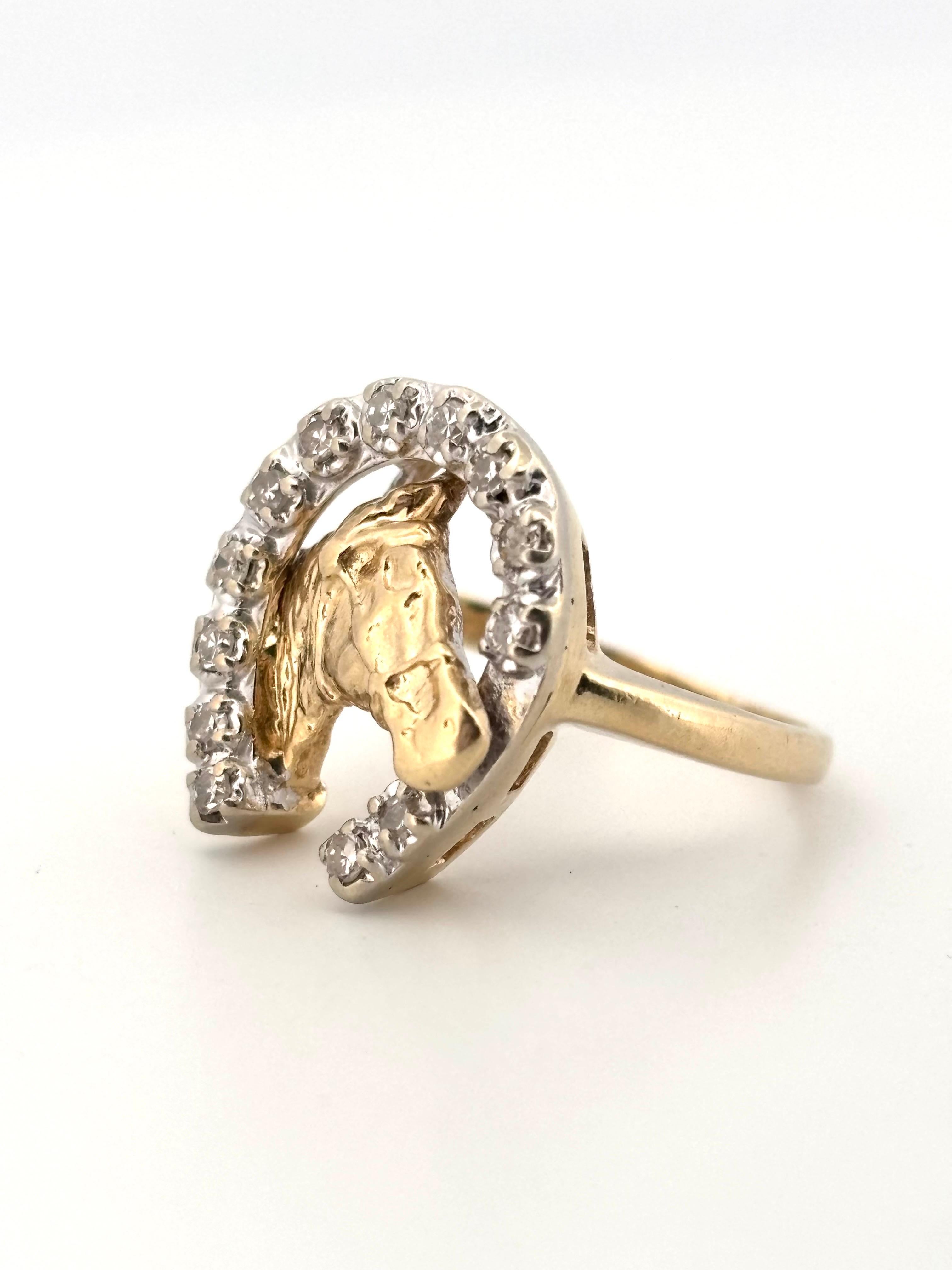 Cette bague unique en or jaune 14 carats à tête de cheval et fer à cheval est un symbole frappant de la passion équestre et de l'artisanat intemporel. La pièce centrale présente une tête de cheval finement détaillée, encadrée dans un motif classique