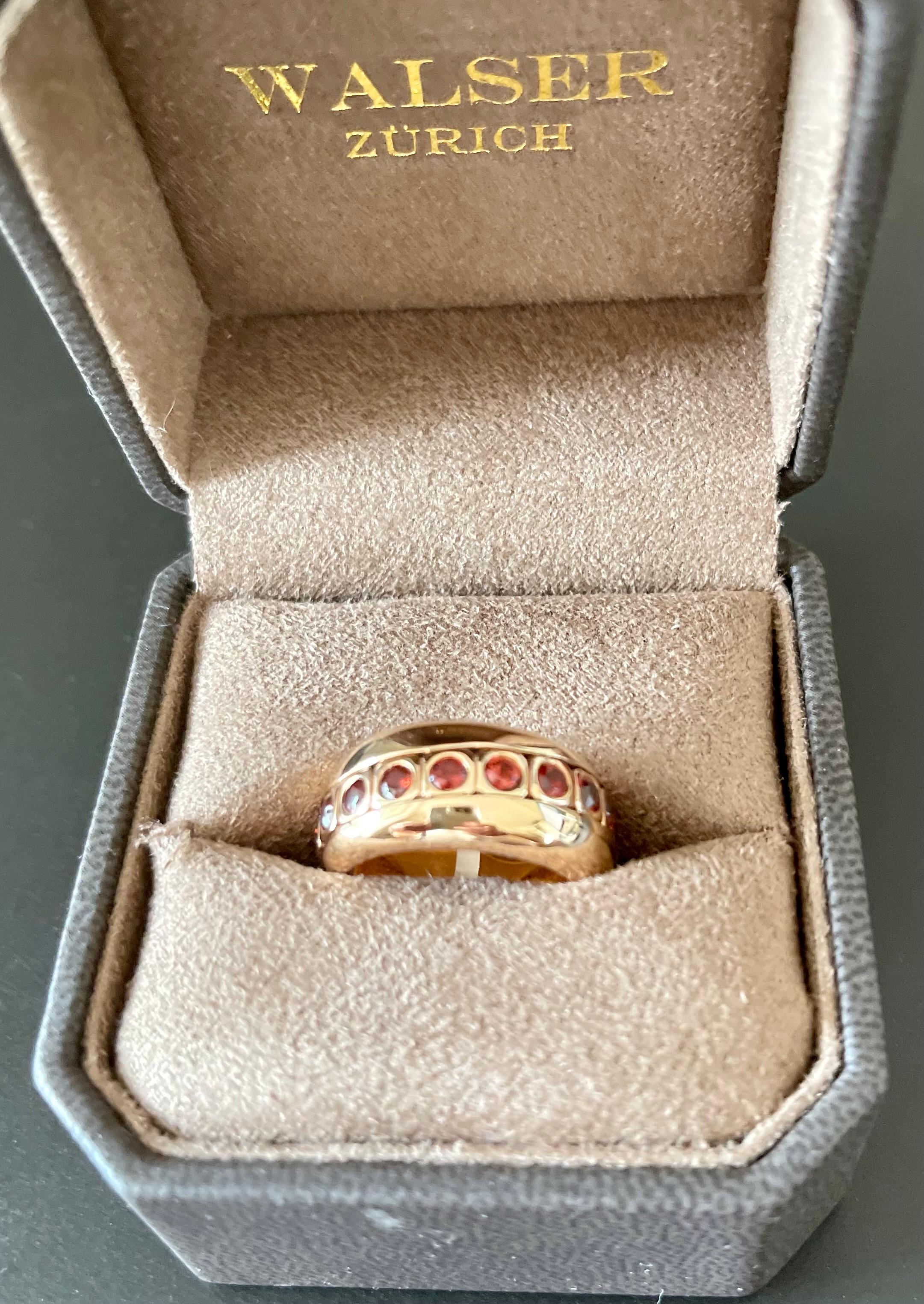 Very special and understated Bandring with a speical feature of a moving Ring inside the ring.
18 K rose Gold band Ring with an inner movable Ring set with 18 vivid orange Mandarin Garnets weighing 2.75 ct. 
The ring is currently size 55 ( american