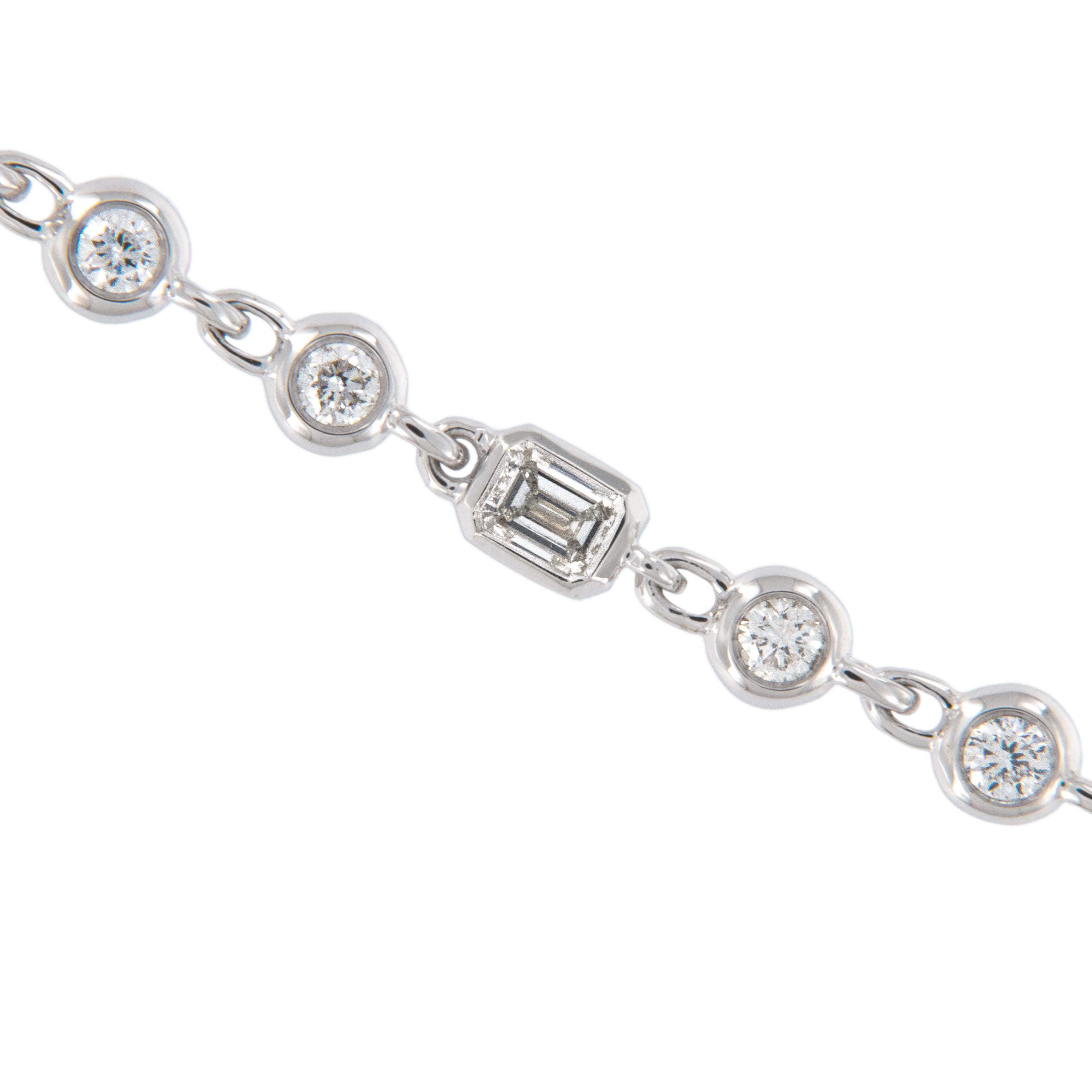 Absolutely stunning! This completely unique diamond necklace boasts 80 bezel set VS, G-H diamonds = 2.46 Ct with three emerald cut diamonds scattered within, finished with a beautiful diamond accented clasp. Holds it's own all by itself but also