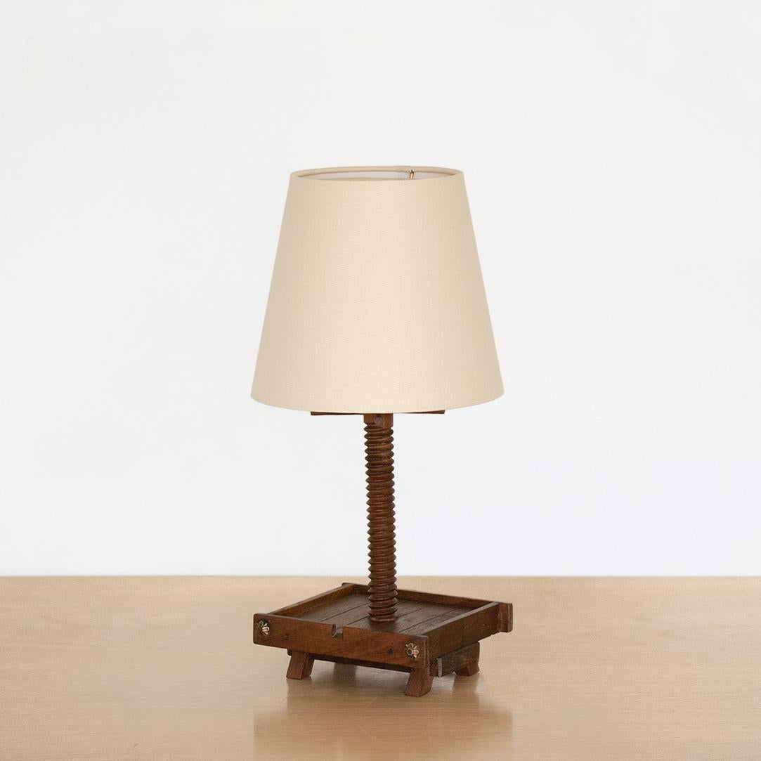 Unique oak wood table lamp from France, 1940s. Square wood base with petite angled feet, ornate brass flower detail and carved stem. Newly rewired and new linen shade. Fun statement piece. Takes one E12 base bulb, up to 40 W or higher using LED.