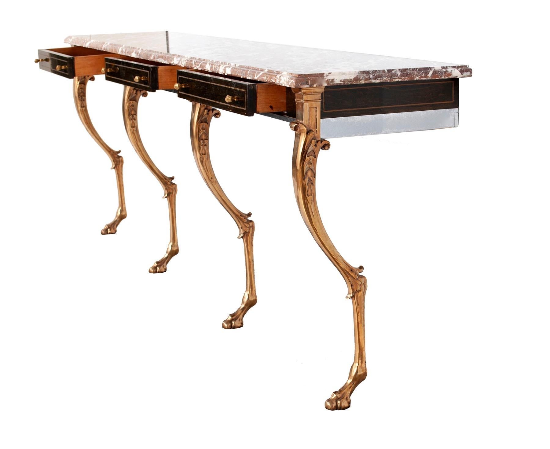 Unique custom 1970s Hollywood Regency sideboard, console or server with Rosso Levanto marble top on four heavy solid stylized brass animal form legs with hoofed feet and nickel frame with three ebonized rosewood drawers, having brass inlay and