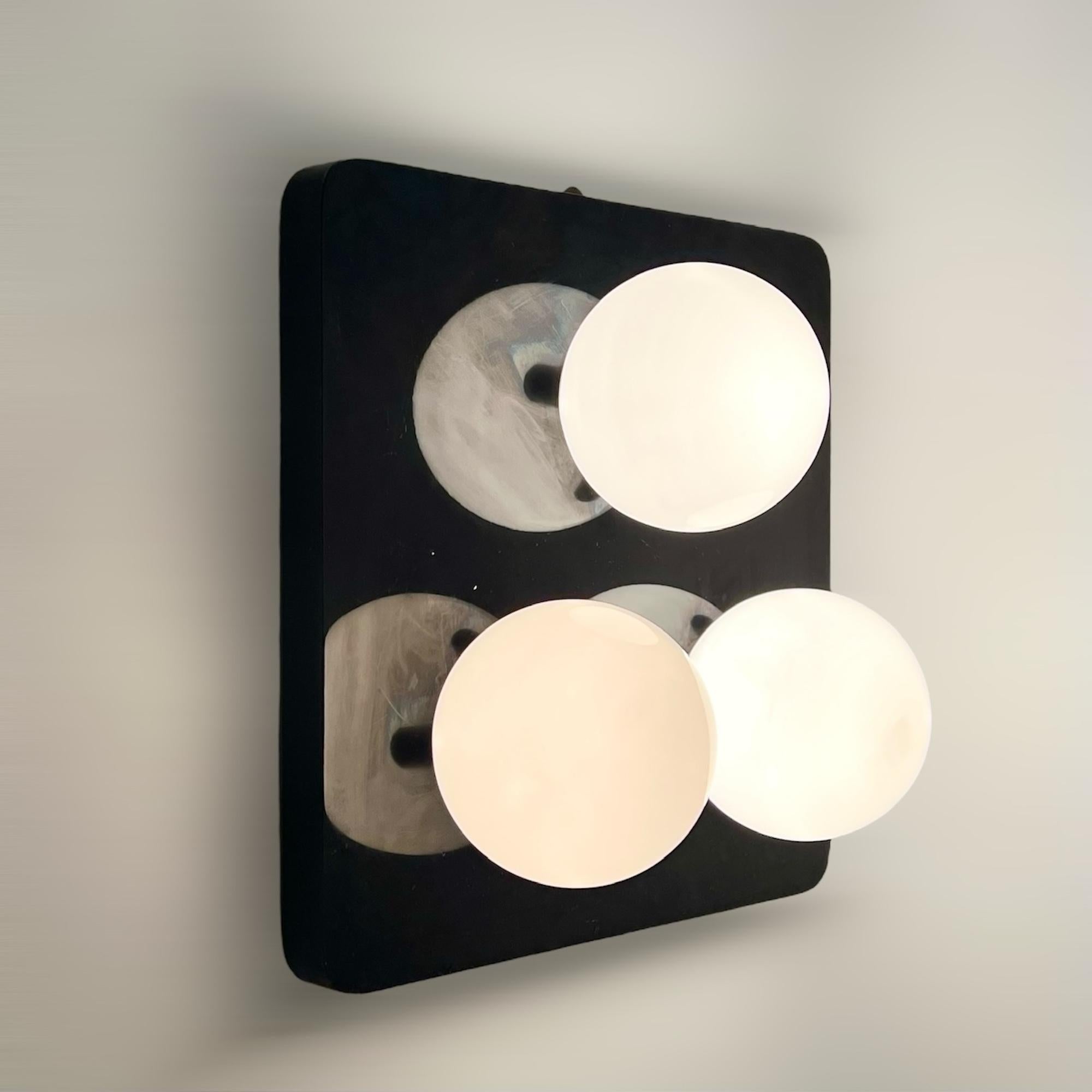 Embrace the distinctive flair of the Seventies with this rare and elegant wall 70s lamp panel. Designed to add a touch of retro sophistication to any space, this piece features a sleek black lacquered wooden frame complemented by three lustrous