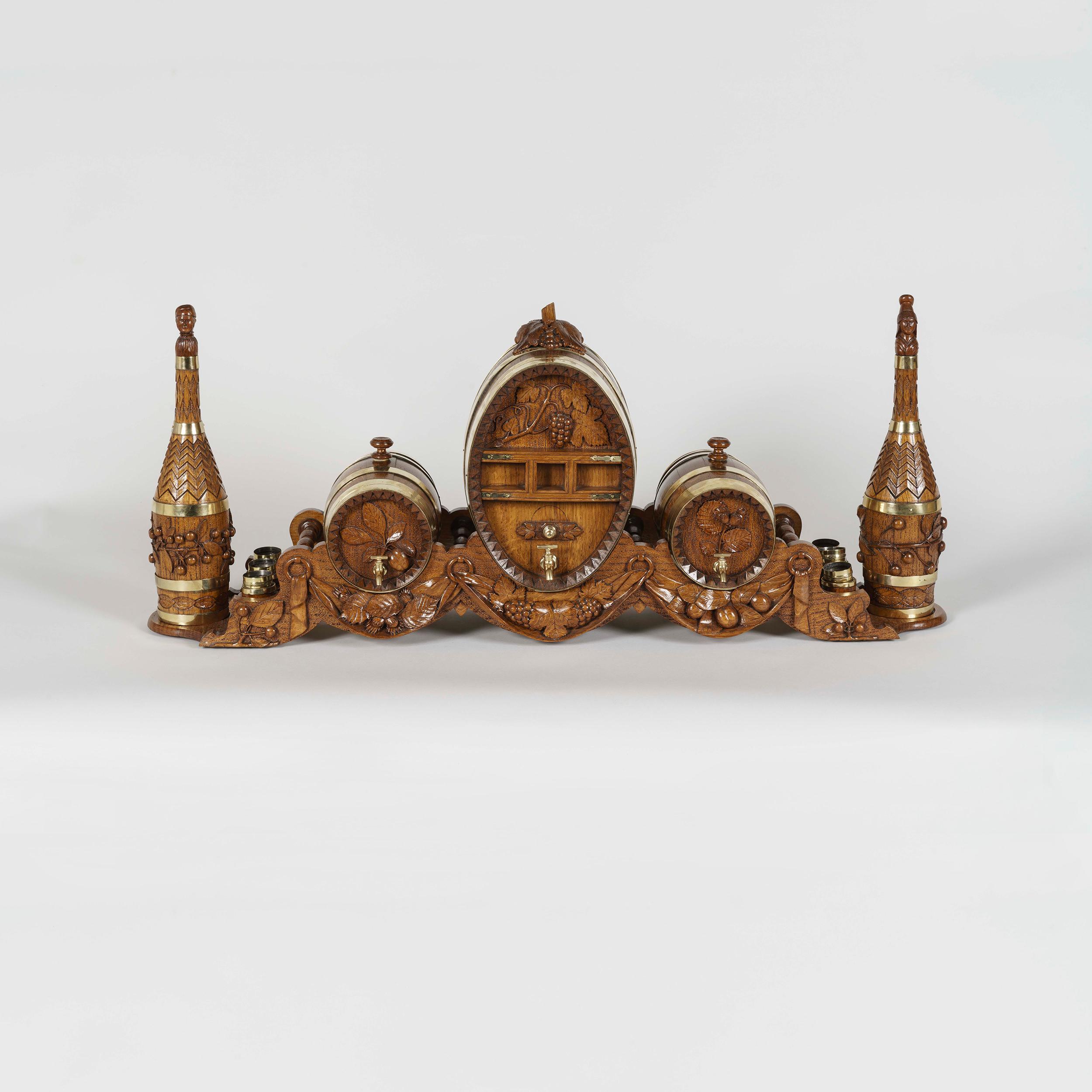 A Tour-de-Force carved oak barrel drinks set

Composed of four barrels and two carafes, with twelve silver gilt and oak glasses from the silversmith Odile Lamy, the entire set resting on carved chevalet supports with relief decoration of vine