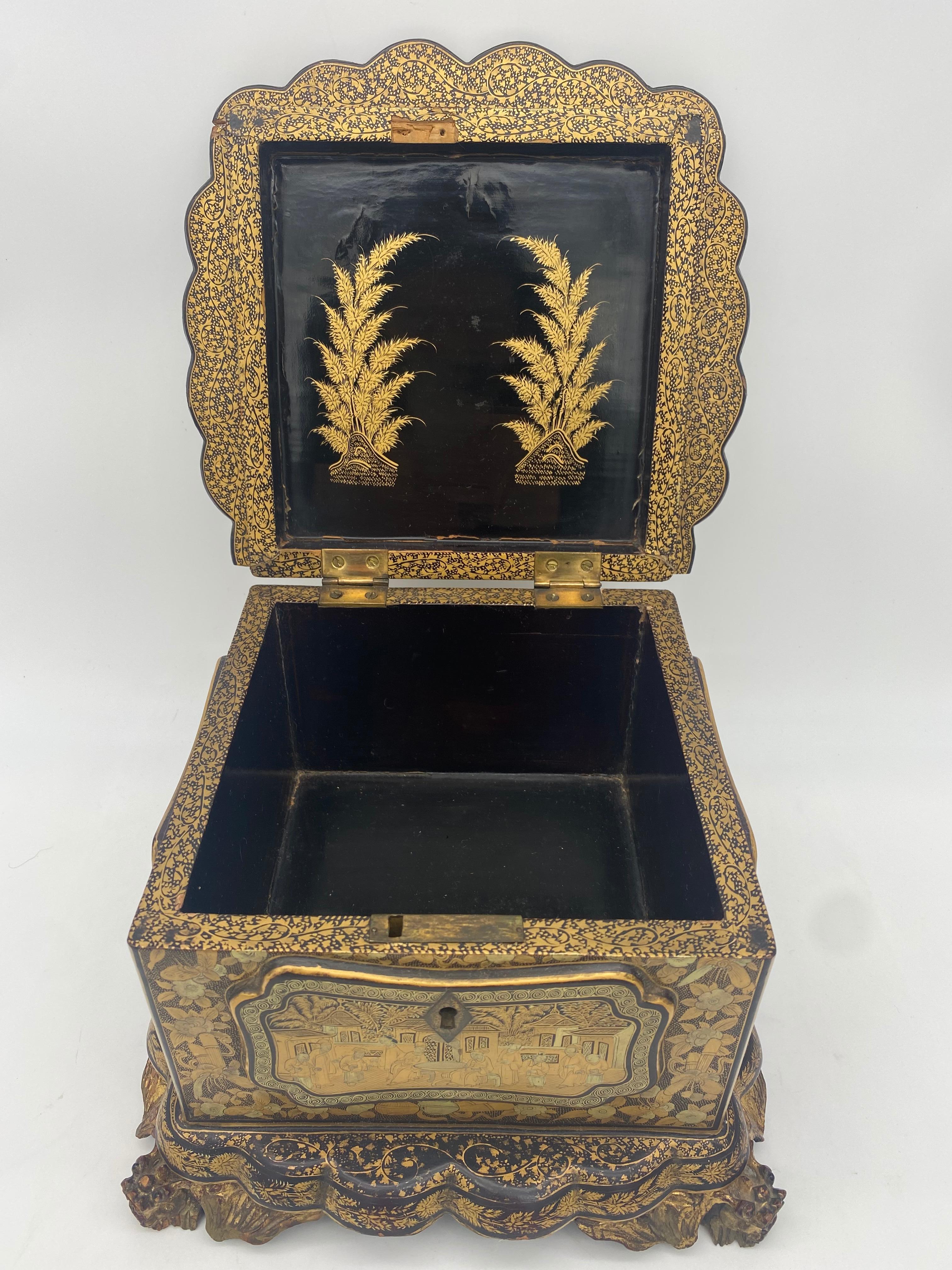 Unique 19th century export Chinese gilt chinoiserie lacquer box with hand painted scenes gilt export black lacquer, this box has a unique shape, it is footed with a scalloped rim around the lid and the base. The lid is hinged, the feet are open