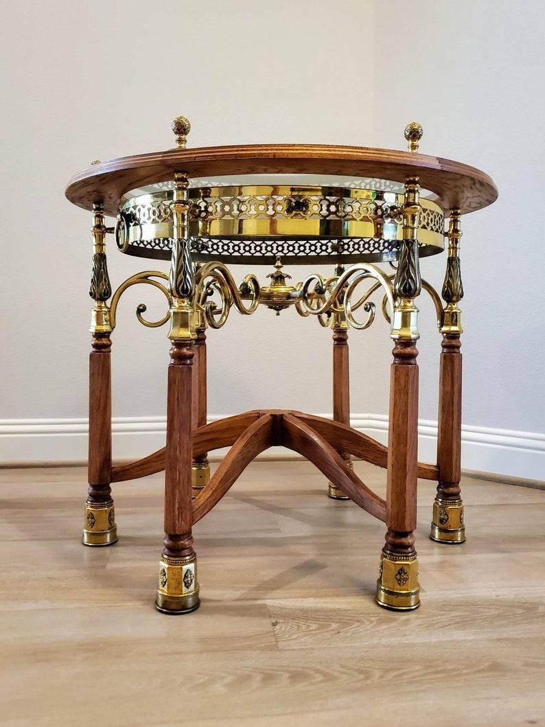 A magnificent handcrafted vintage oak wood framed glass top haberfeld table with substantial gilded bronze and pierced brass accents, having six legs joined by dovetailed central strecher hexagonal support, rising on six gilt brass capped feet.
