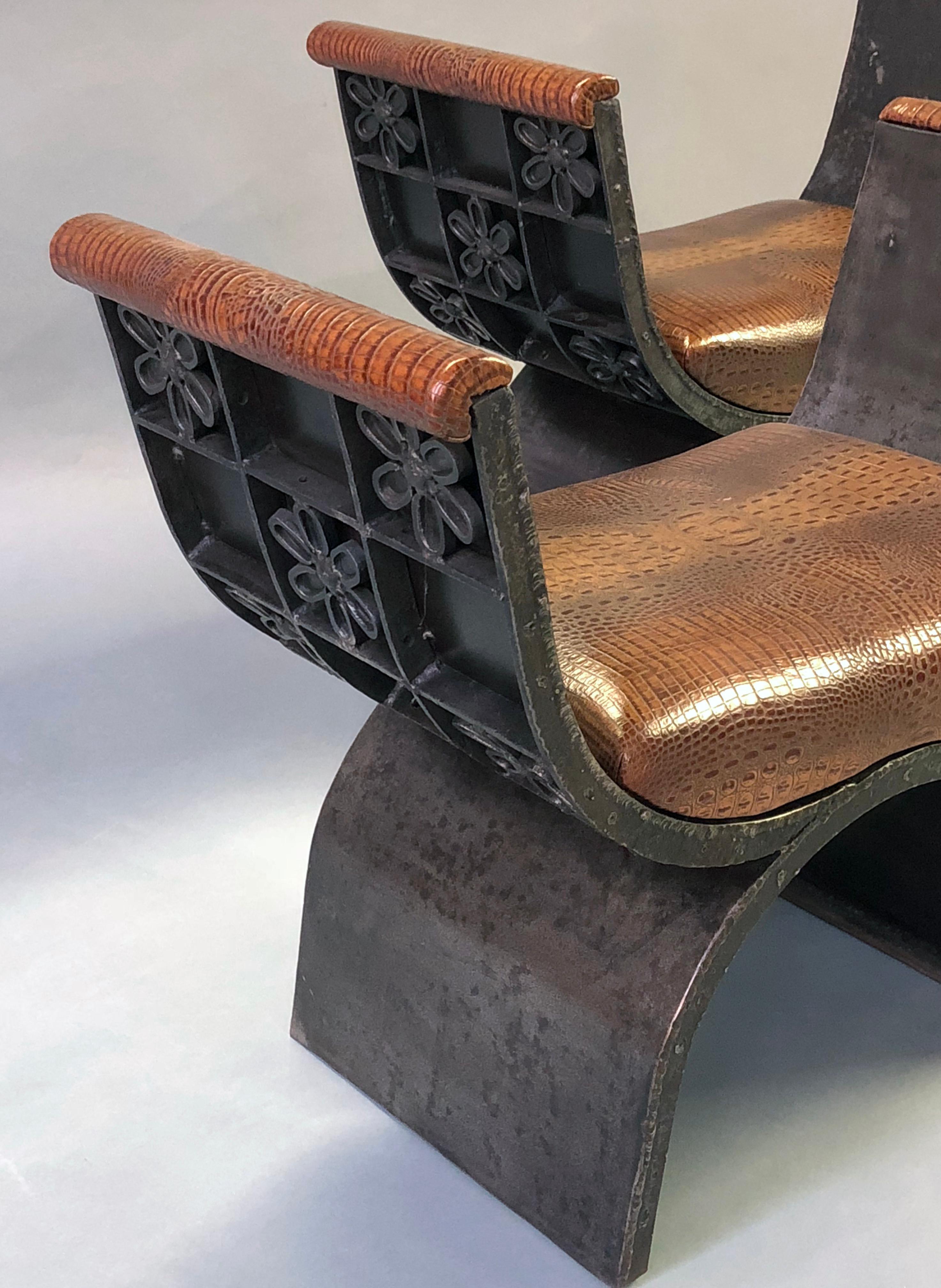 A unique and boldly-scaled French industrial iron Curule-form benches with faux alligator leather seats; great statement pieces, each of Curule form in a patinated iron finish; with new faux alligator upholstery.