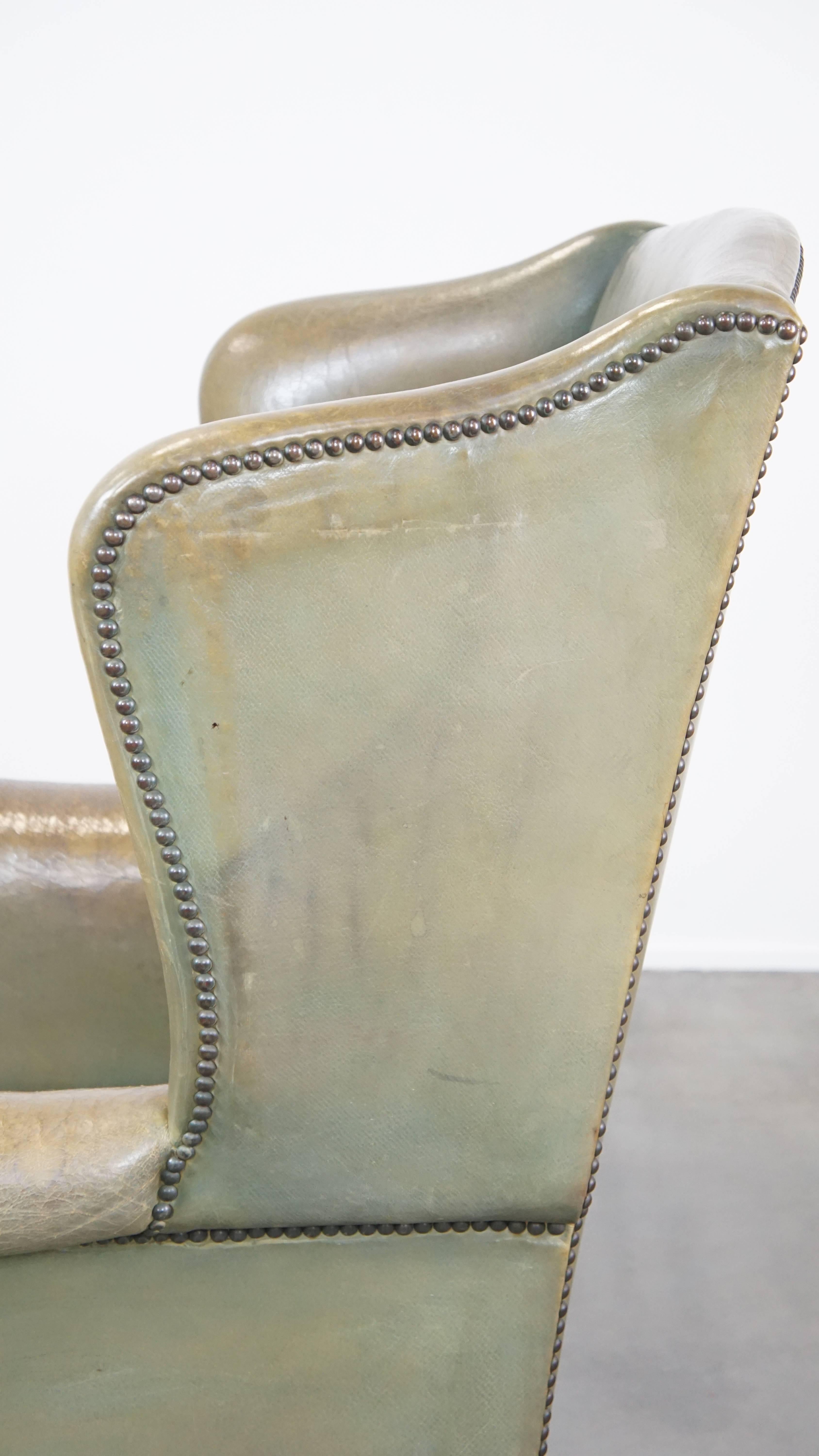 Unique and characterful green cowhide leather armchair with a beautiful patina For Sale 4
