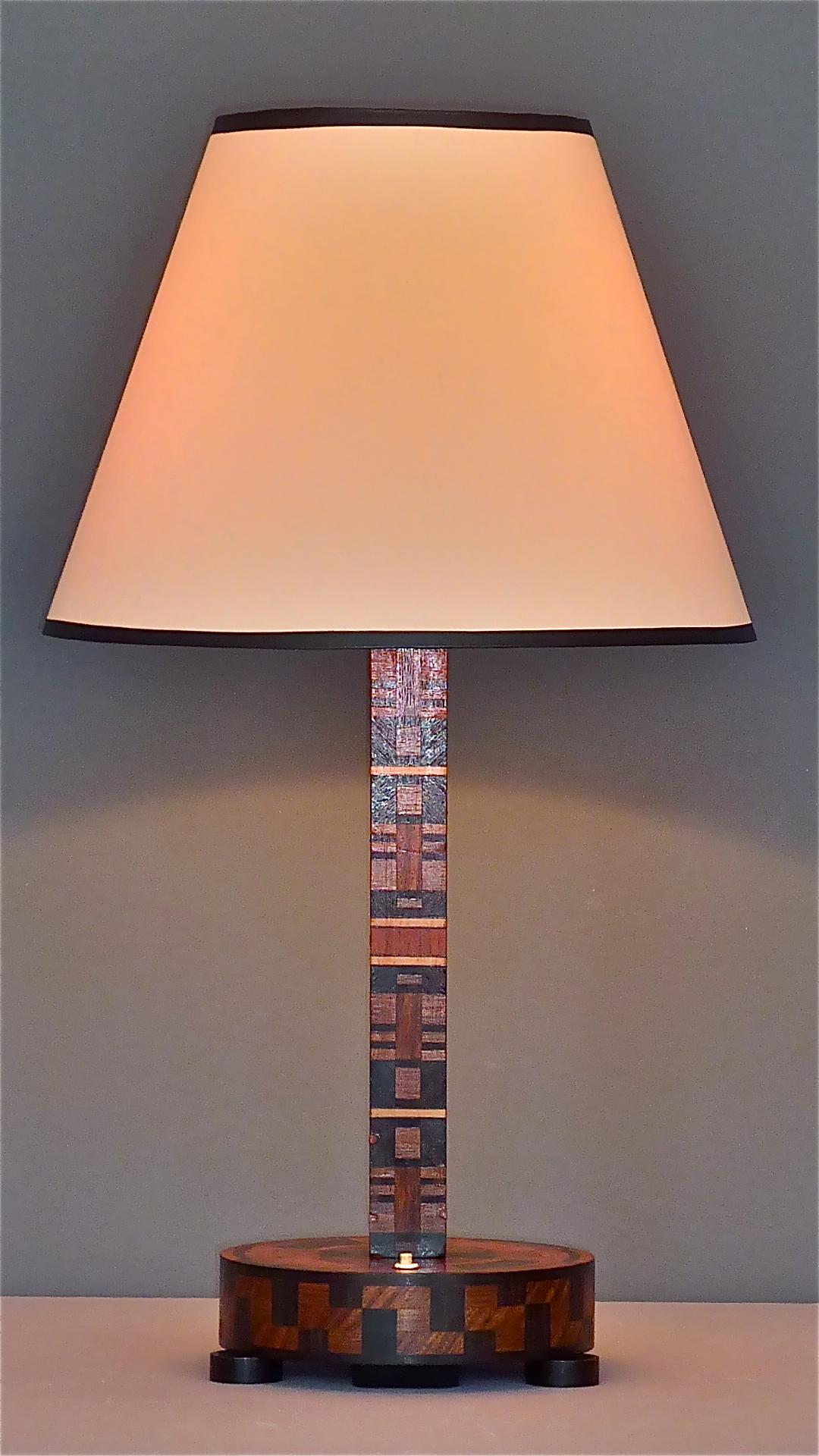 Antique Art Deco / Bauhaus wood marquetry table lamp which can be dated France or Germany, circa 1920-1930. The lamp base has a wonderful exciting geometric alternating pattern of dark brown and blonde fruitwood, an integrated switch within the drum