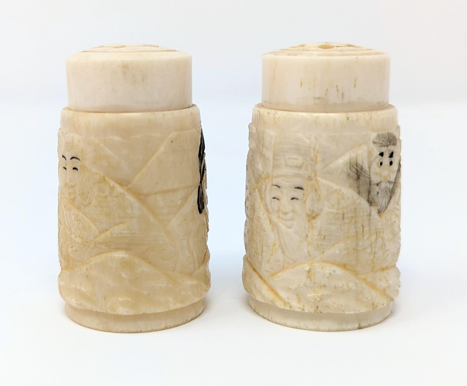 Beautifully hand carved bone salt and pepper shakers with light inkwork. Either Japanese or Chinese, possibly representing the Seven Lucky Gods. Measures 1.2 inches in width by 2 inches in height. The tops screw off and on, but please note there is