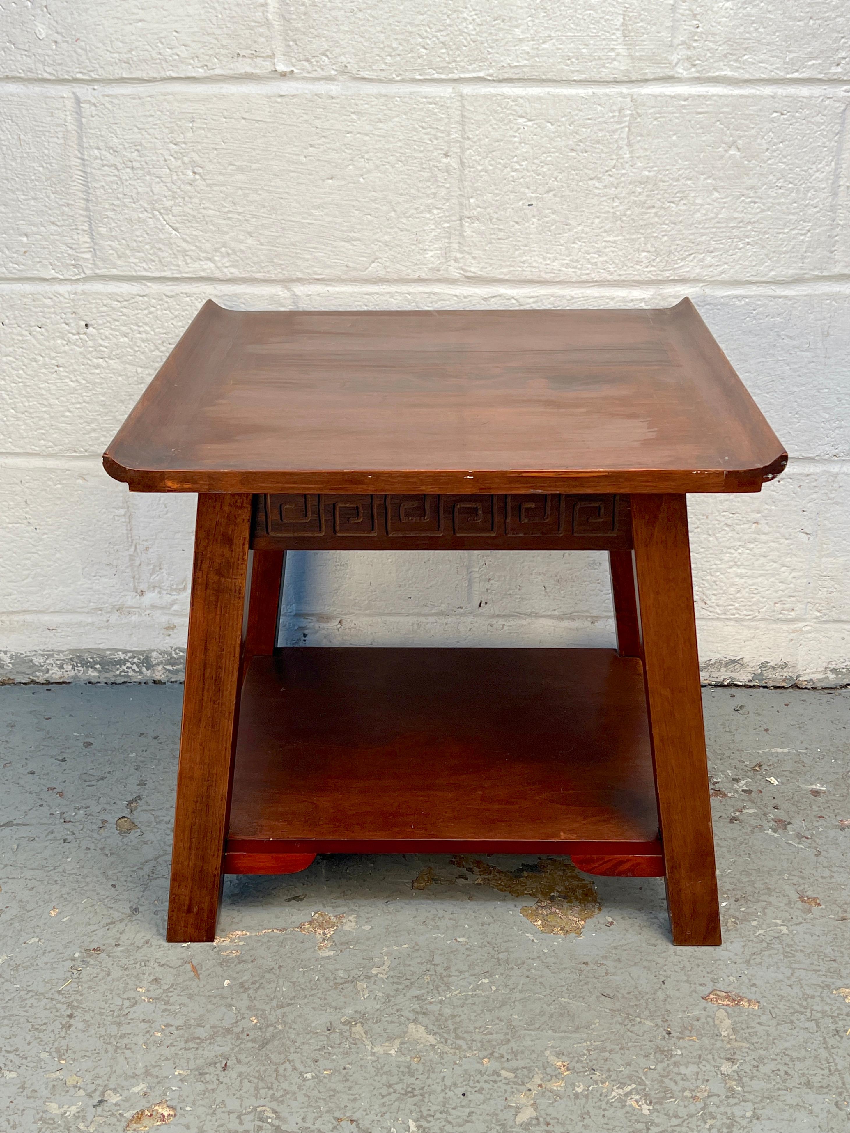 Elegant antique Chinese tea table featuring intricate carved trim and a gracefully curved top profile. The piece reflects fine craftsmanship and traditional design, offering both visual interest and functional charm. A beautiful addition to any