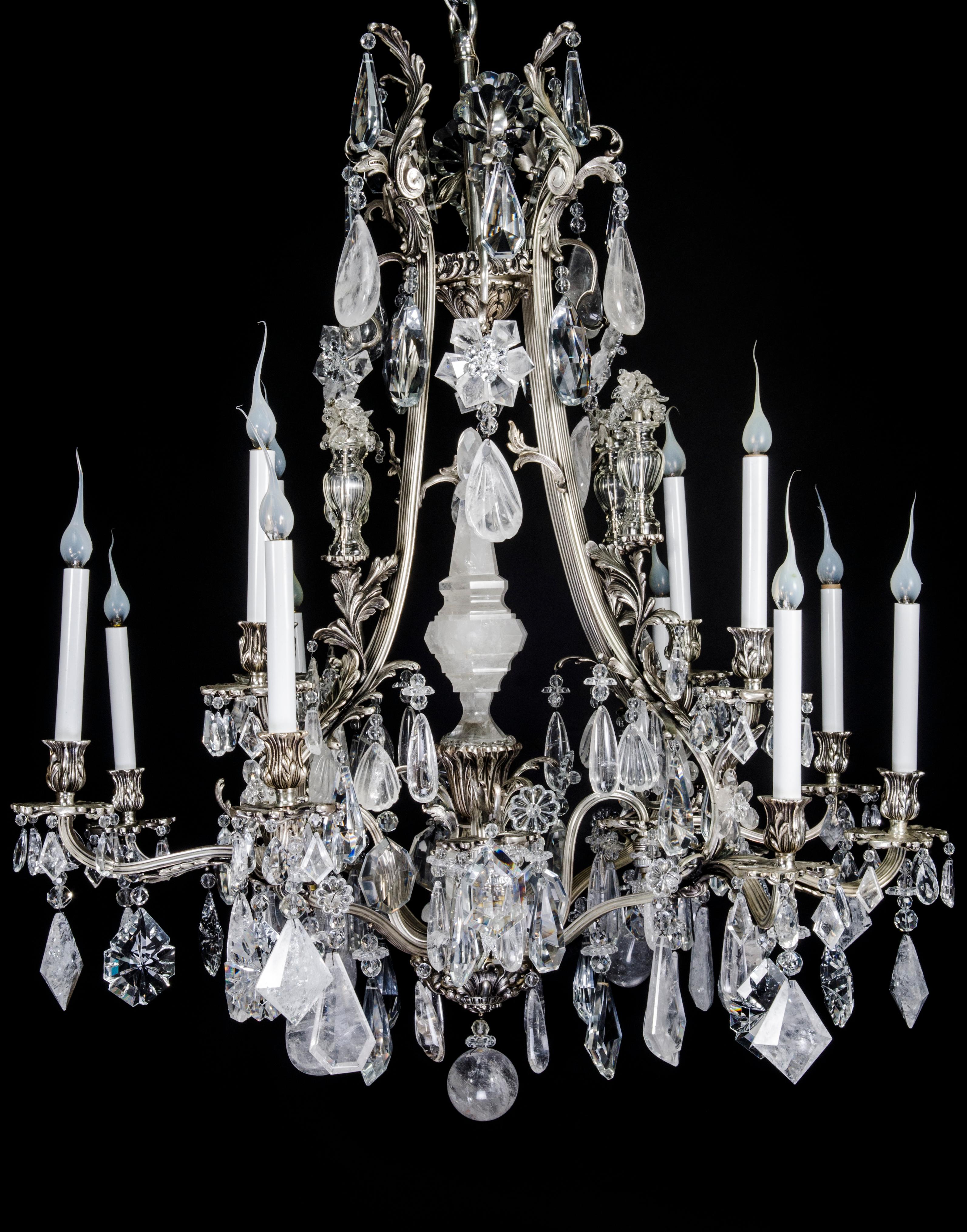 A unique and large antique French louis XVI style silvered bronze, cut rock crystal and cut-crystal multi light double tier chandelier of exquisite quality embellished with fine cut rock crystal prisms, rock crystal flowers, four corner crystal