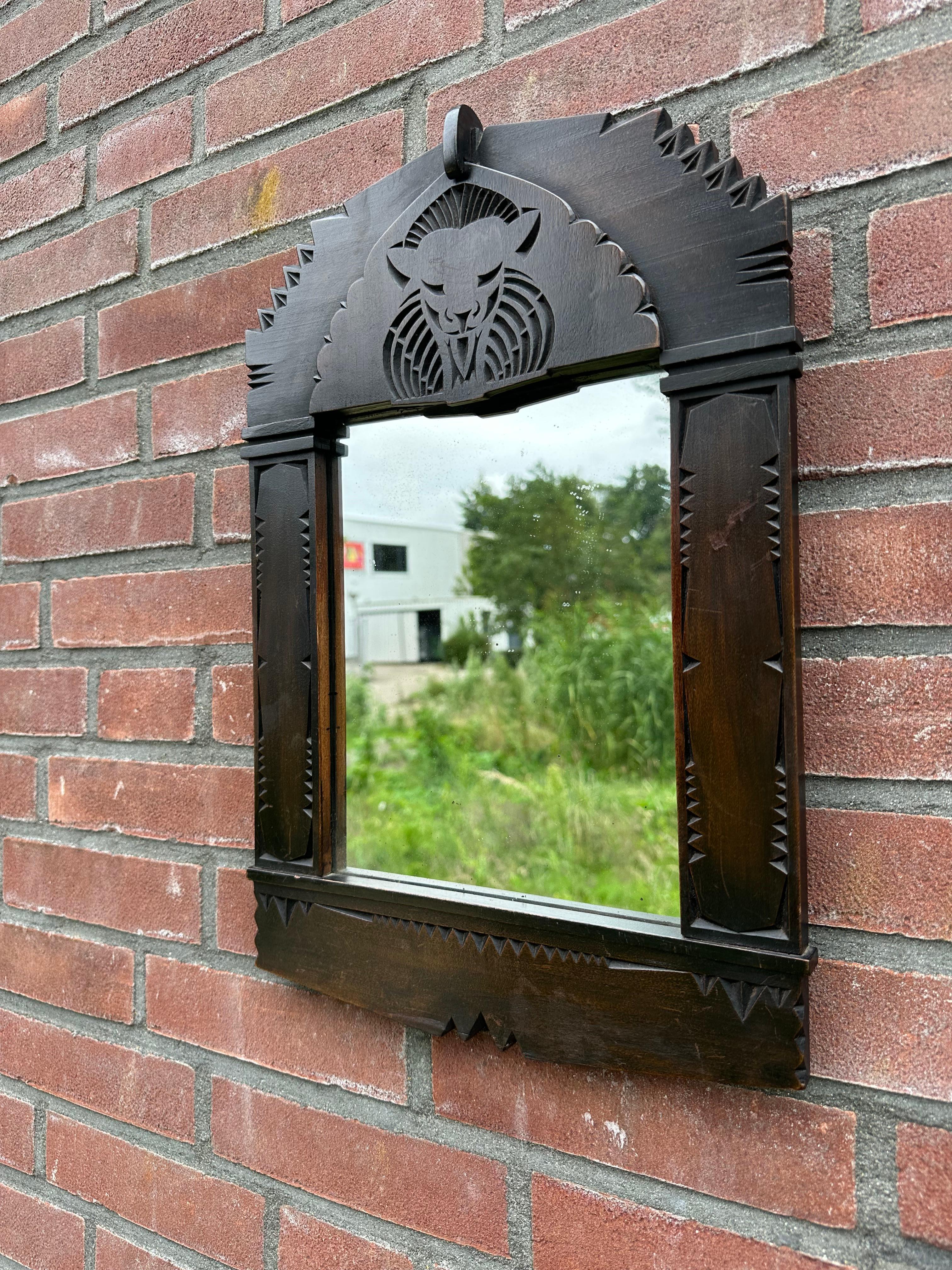 Striking, geometrical design wall mirror with handcarved lion / cat carving.

Via one of our trade contacts we recently purchased this perfectly hand carved sculptural wall mirror. This all handcarved wooden frame displays in the top a perfectly