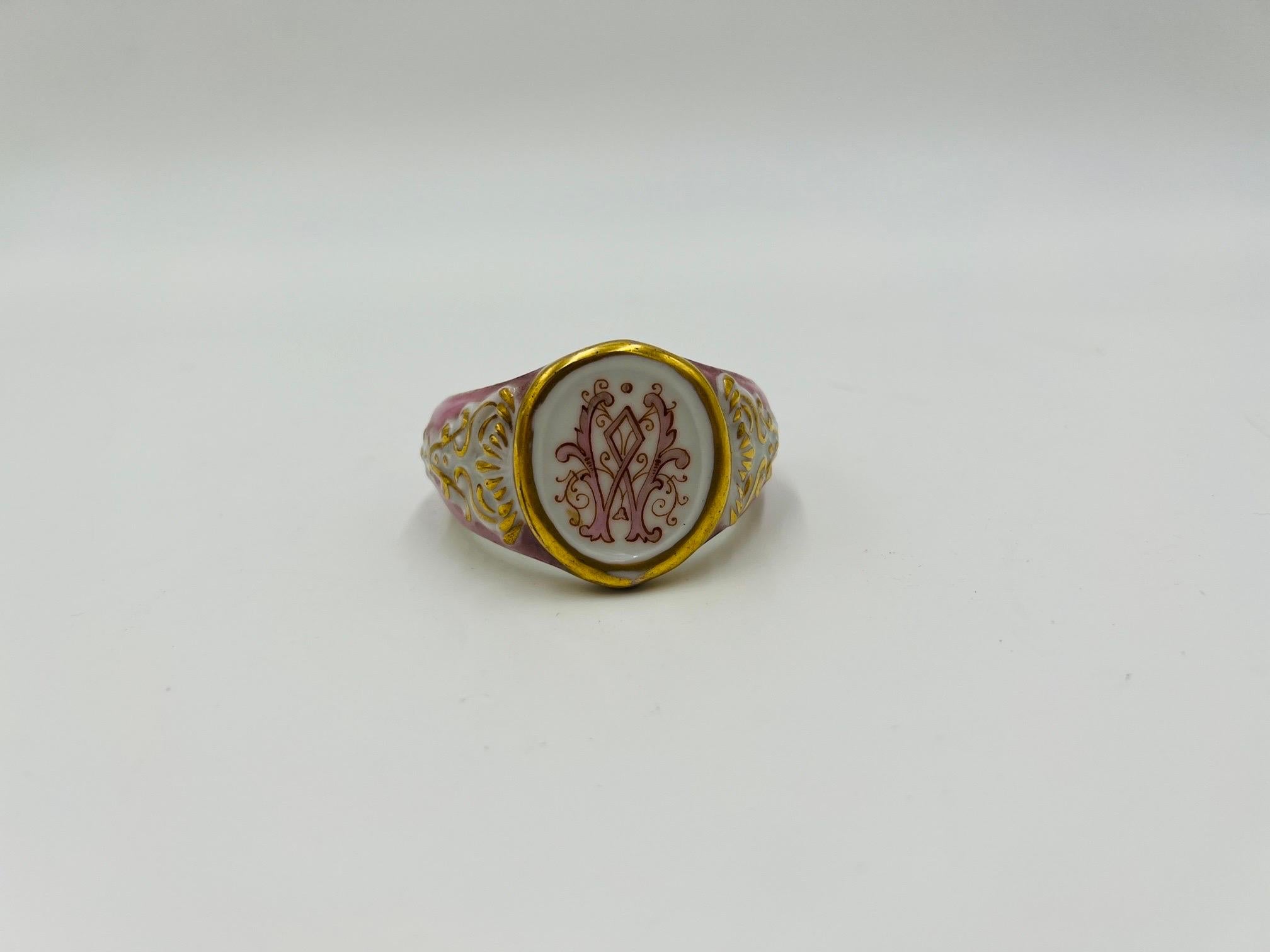 An antique 19th century old paris porcelain napkin ring. Finely decorated with a “W” monogram to center of face, acanthus gilt accents and a pink body. Unmarked.