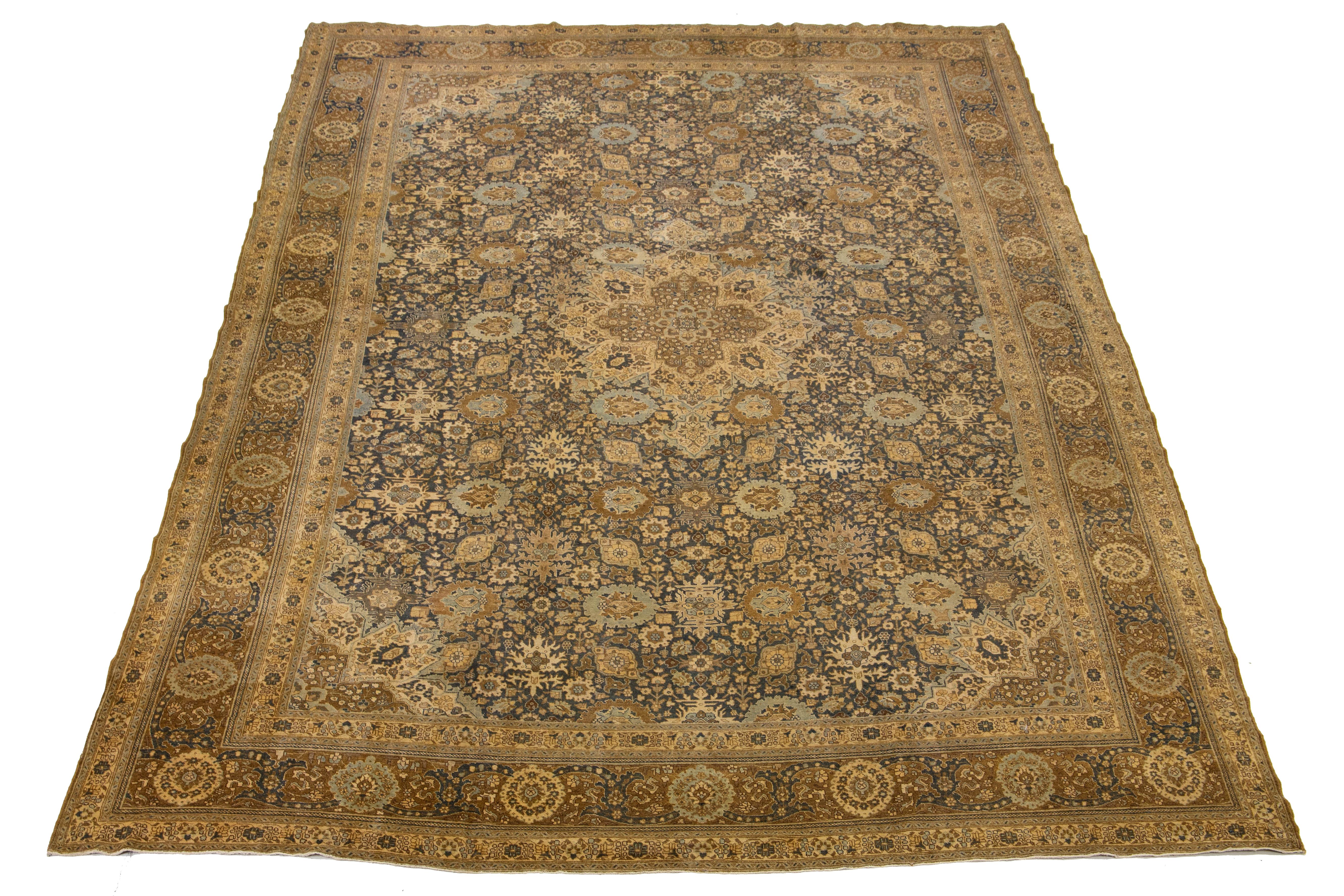 Questo squisito tappeto persiano Tabriz antico del 1890 mostra con orgoglio un sorprendente sfondo blu navy, intricato da un accattivante motivo floreale all-over. Gli eleganti accenti in beige e marrone ne esaltano la bellezza, rendendolo un pezzo
