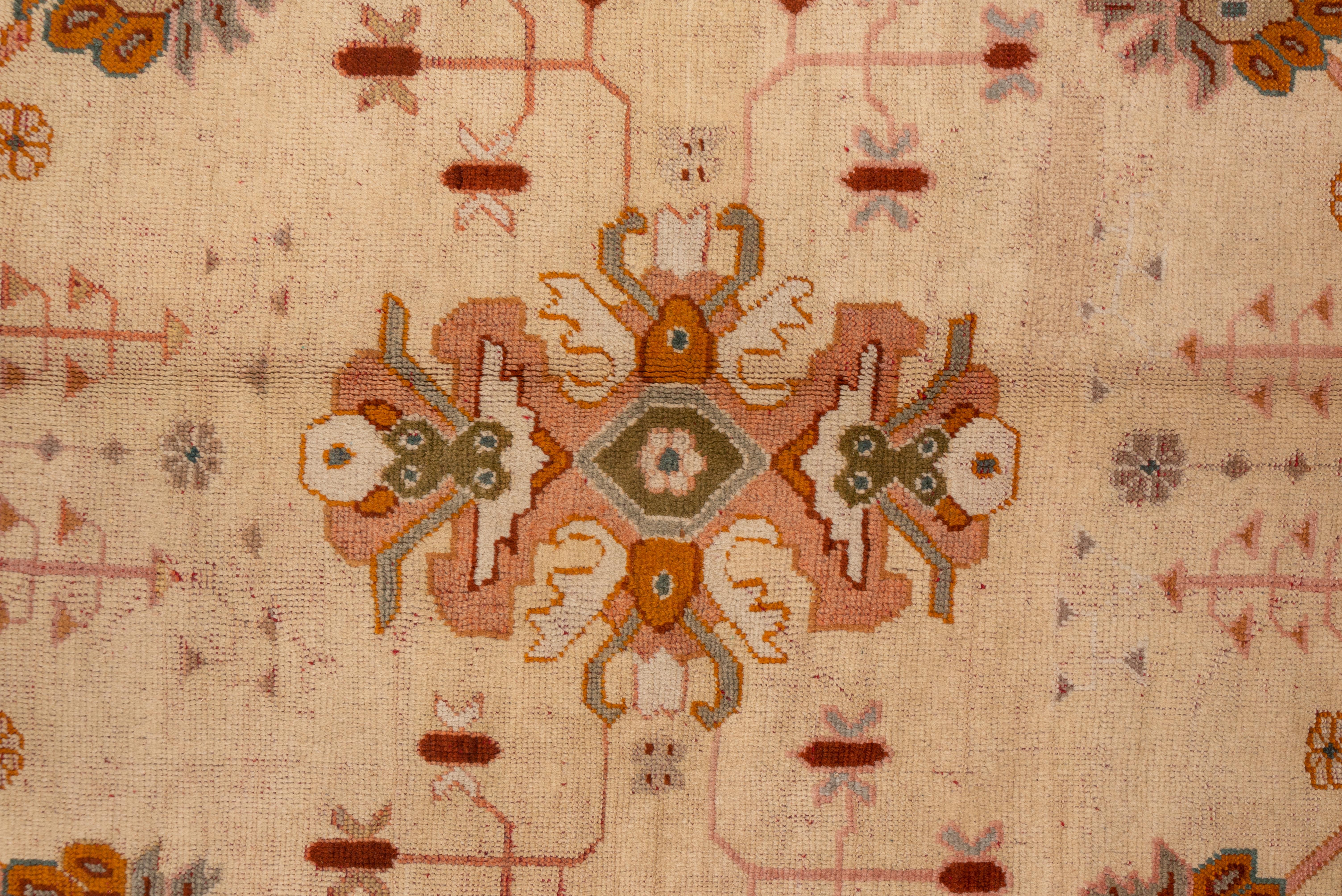 Noué à la main Tapis turc ancien et tribal d'Oushak, terrain entièrement crème, bordures roses et orange