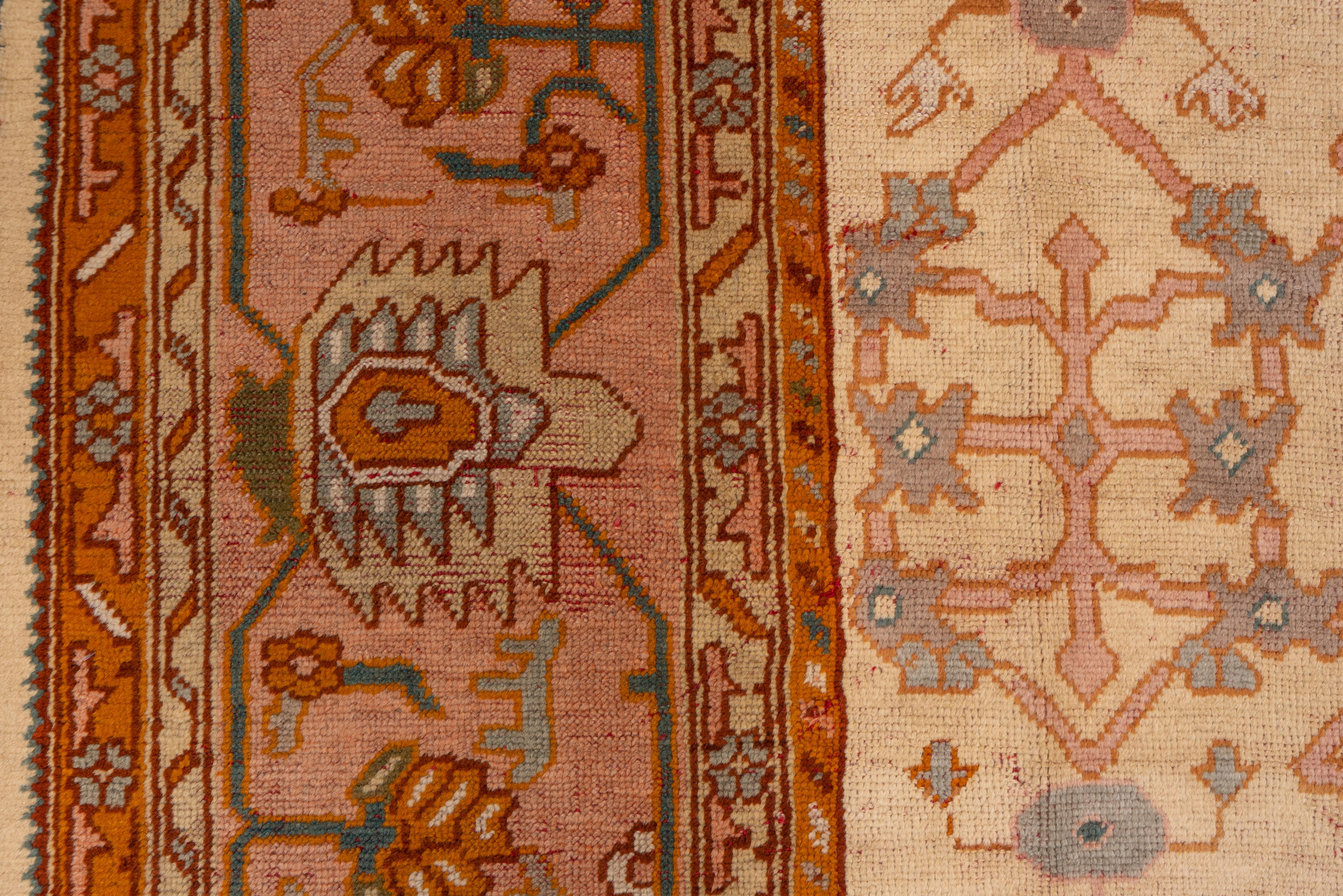 Début du 20ème siècle Tapis turc ancien et tribal d'Oushak, terrain entièrement crème, bordures roses et orange
